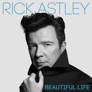 Black and white portrait of Rick Astley with the text 'Rick Astley' and 'Beautiful Life' in blue, looking directly at the camera with his hand near his collar.