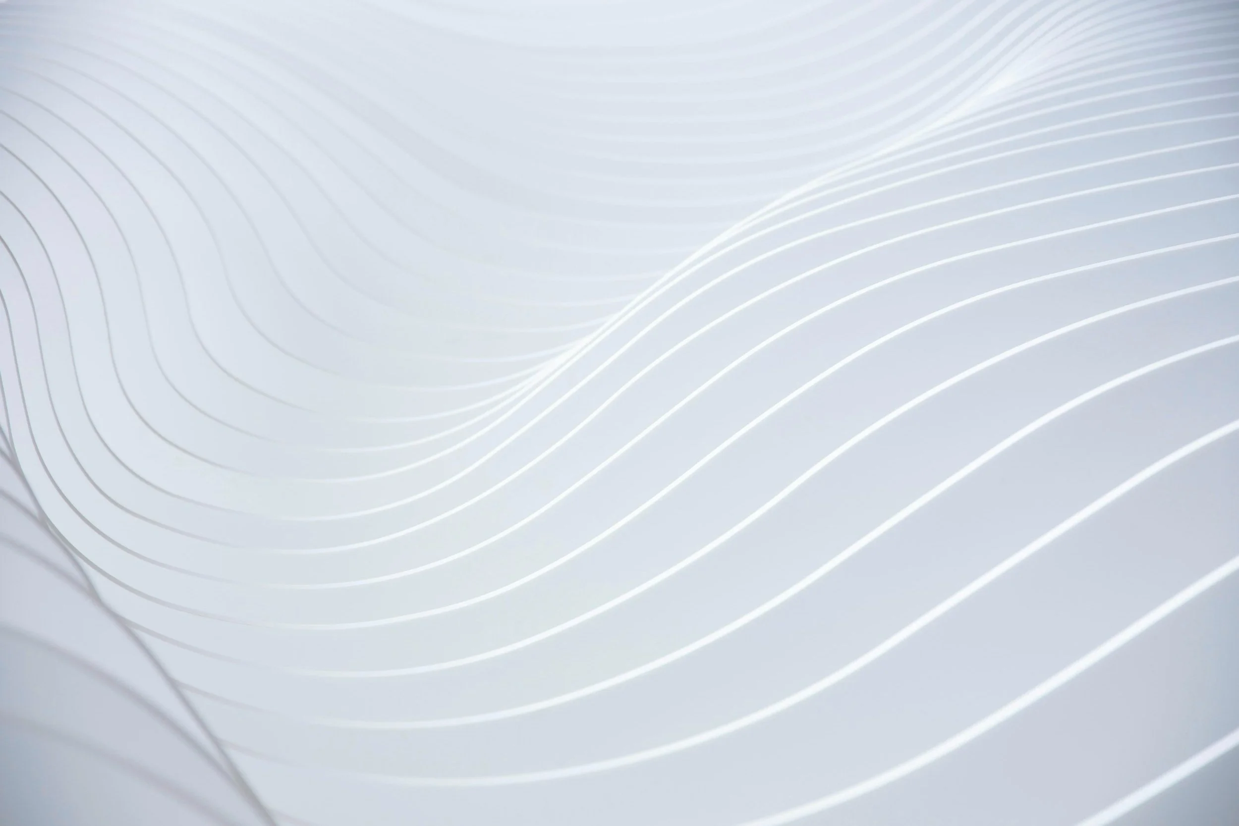 Abstract image with white wavy lines on a light gray background.