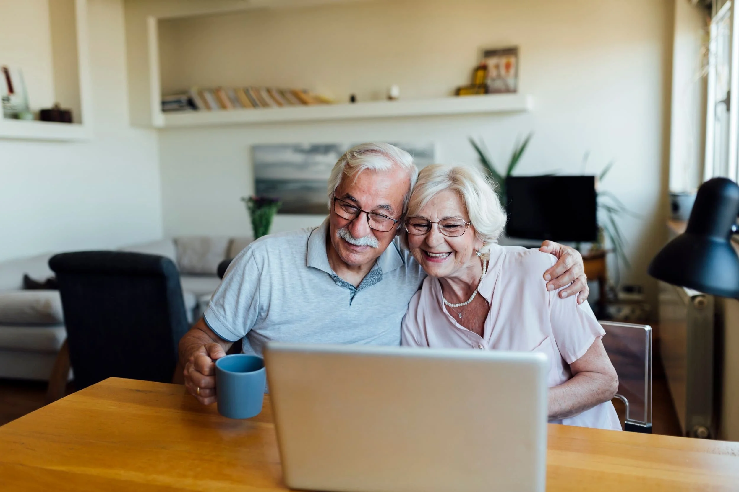 Elderly Couple smiling at laptop.