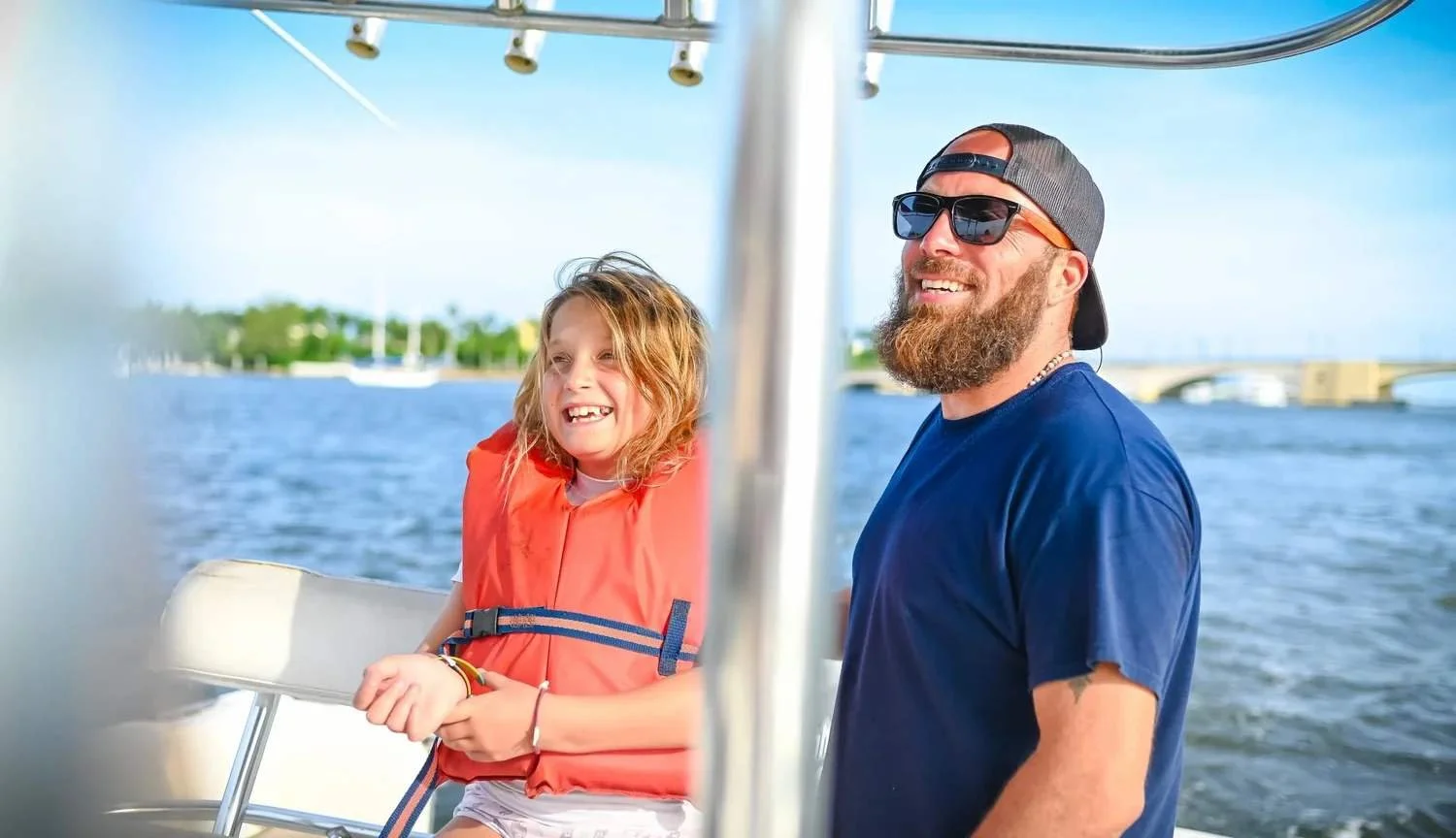 Father and daughter smiling on a boat