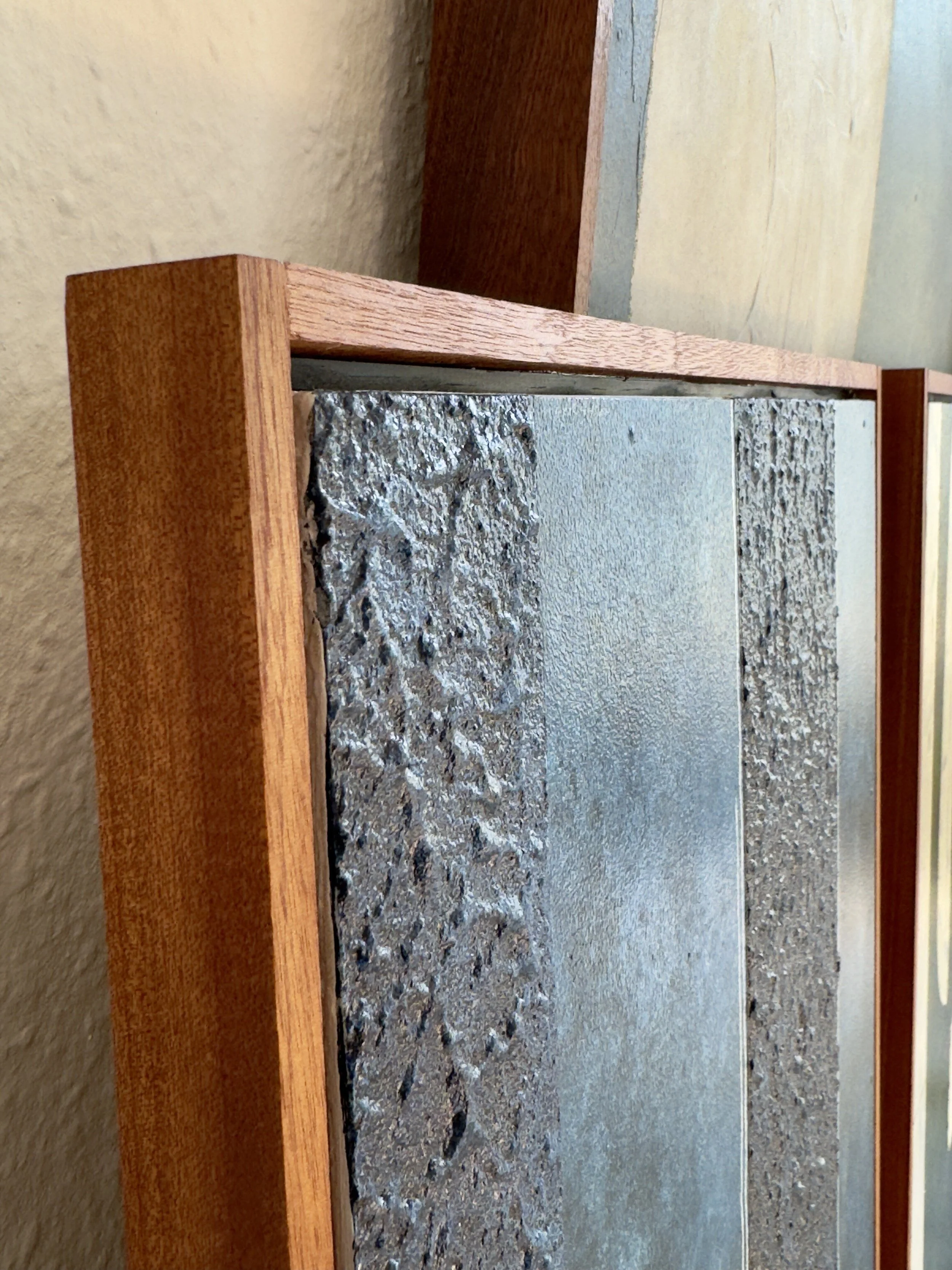 Nahaufnahme eines Fächers mit Holzrahmen und unterschiedliche Texturen auf der Oberfläche, darunter steinartige Muster.