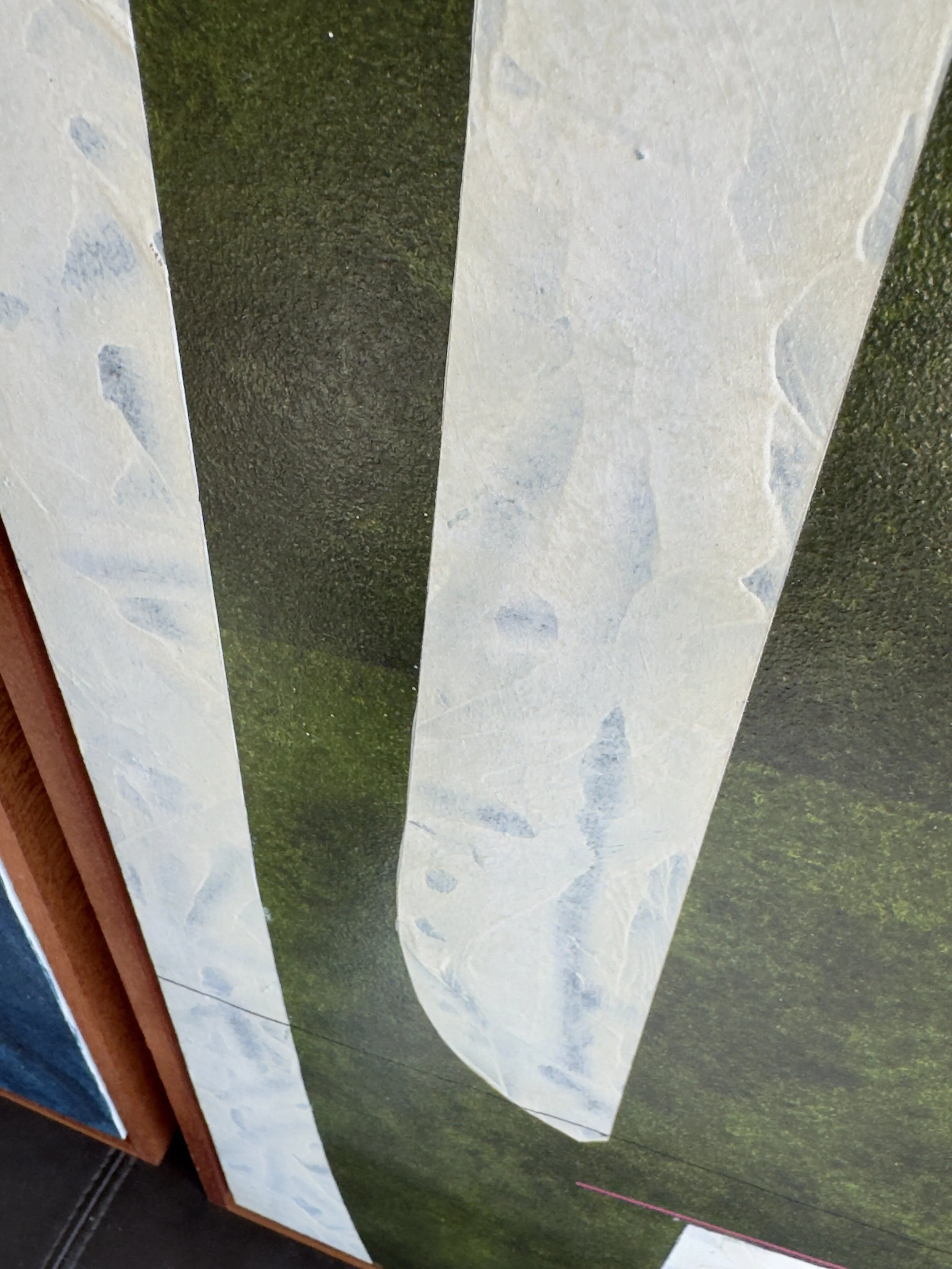 Eine fotografierte Wand mit einem großen Wandbild, das Berg- oder ländliche Landschaft zeigt.