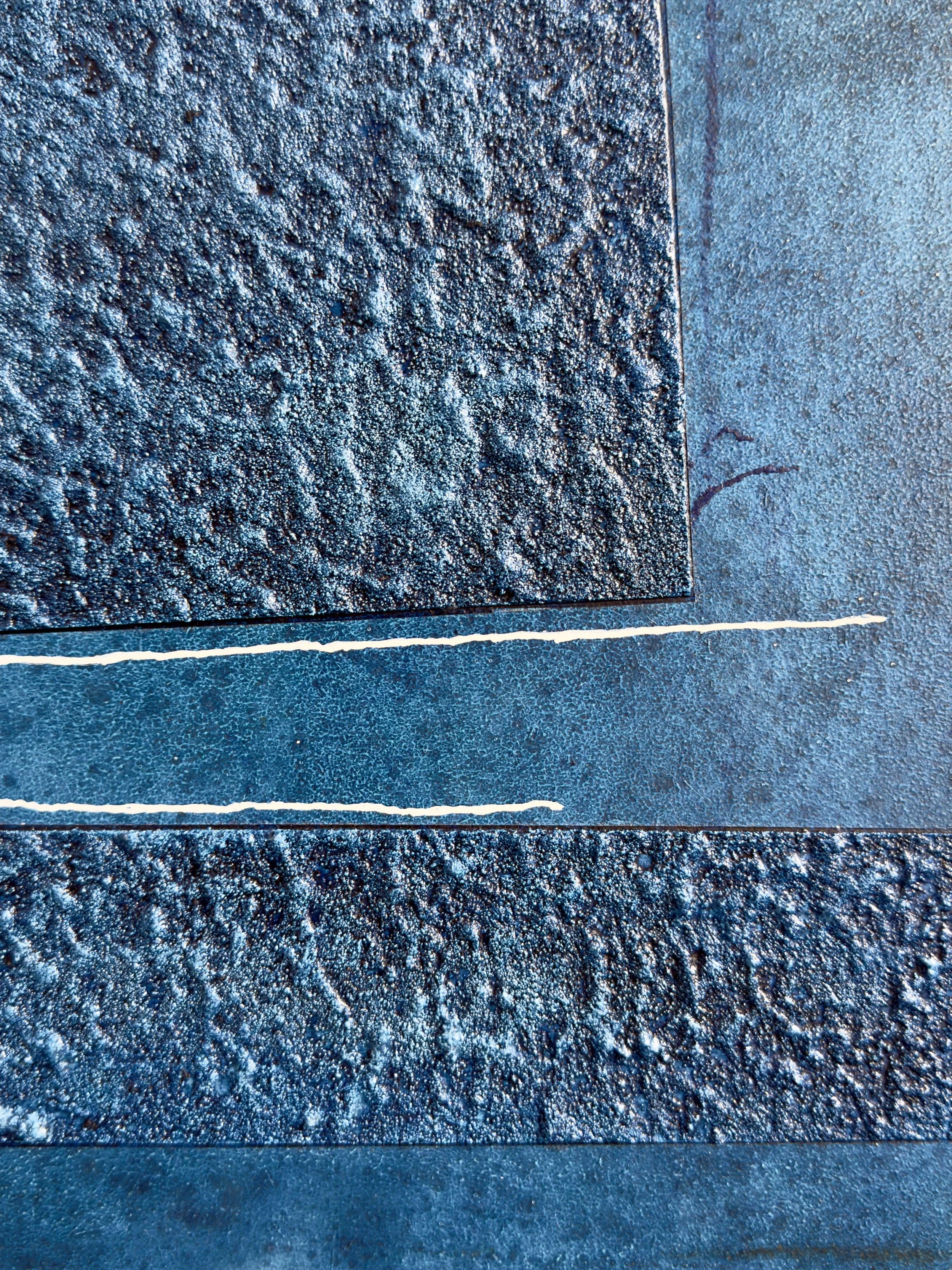 Nahaufnahme von verschiedenen Texturen und Oberflächen, darunter eine rauen, gelochte Oberfläche und glatte Metallstreifen mit weißen Linien.