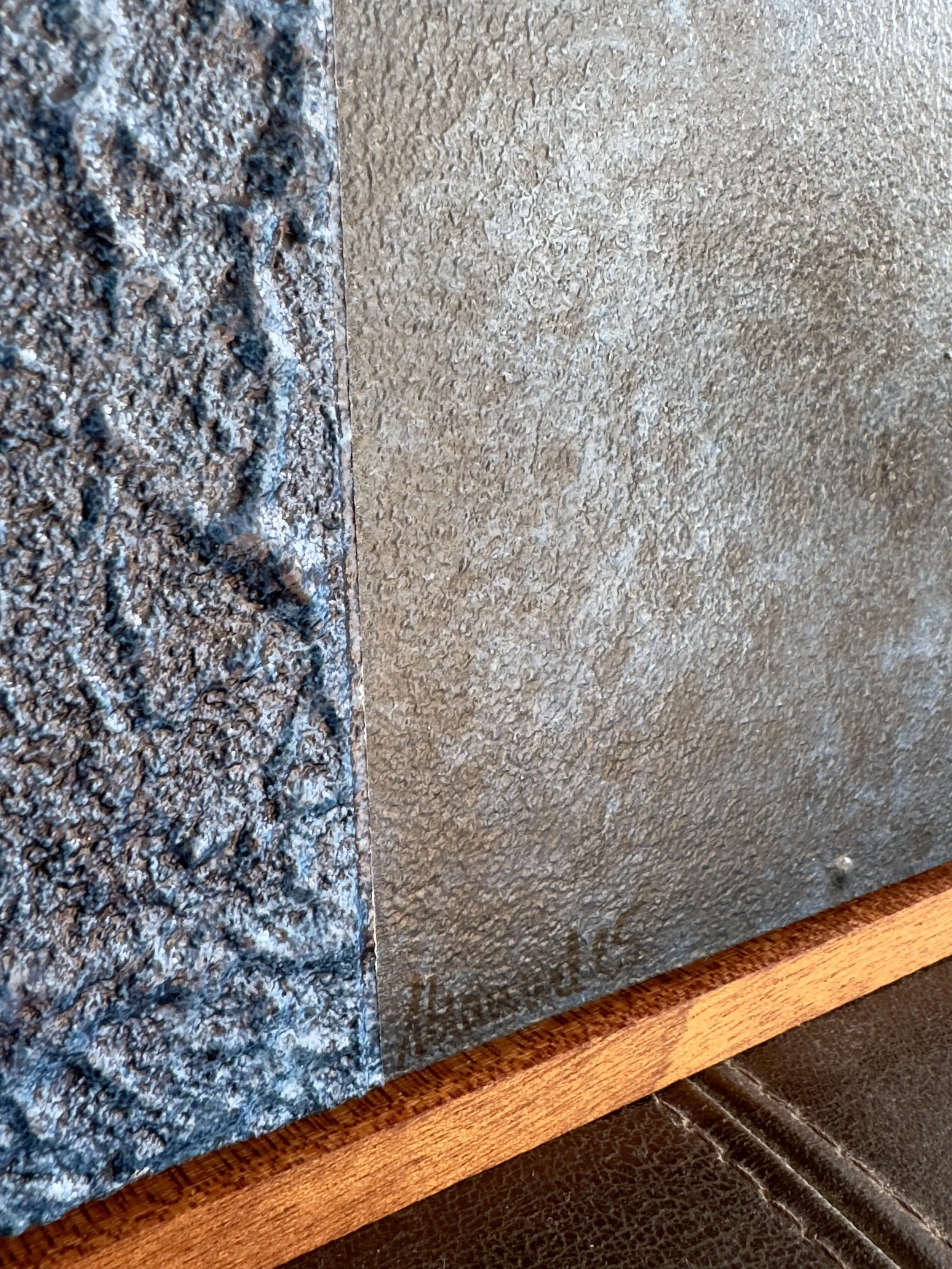 Nahaufnahme einer Wand, die auf einer Seite mit rauer, dunkler Steinoptik und auf der anderen Seite mit glatter, heller Putzstruktur bedeckt ist.