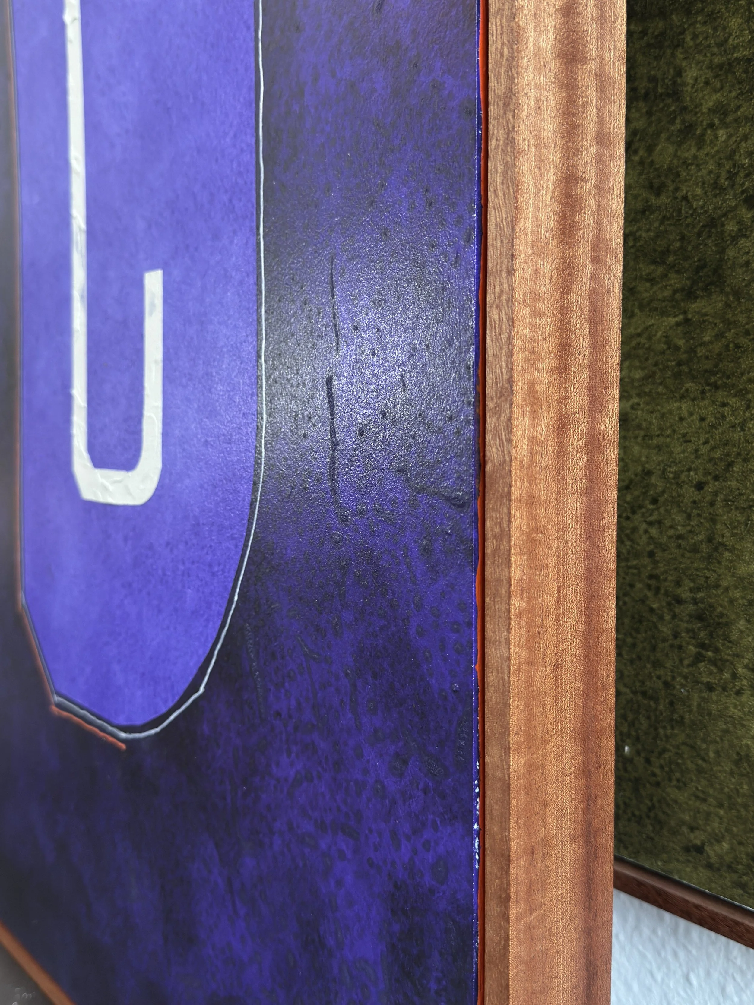 Ein blauer Tisch aus Holz mit weißen Linien und Buchstaben, mit einer braunen Rahmenlage und einer grünen Wand im Hintergrund.