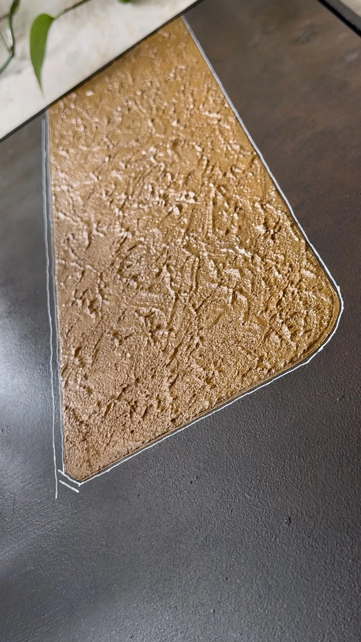 Modell eines dreieckigen Geografie- oder Topografie-Puzzles mit erhabenen Karten- oder Konturdetails auf einem grauen Tisch