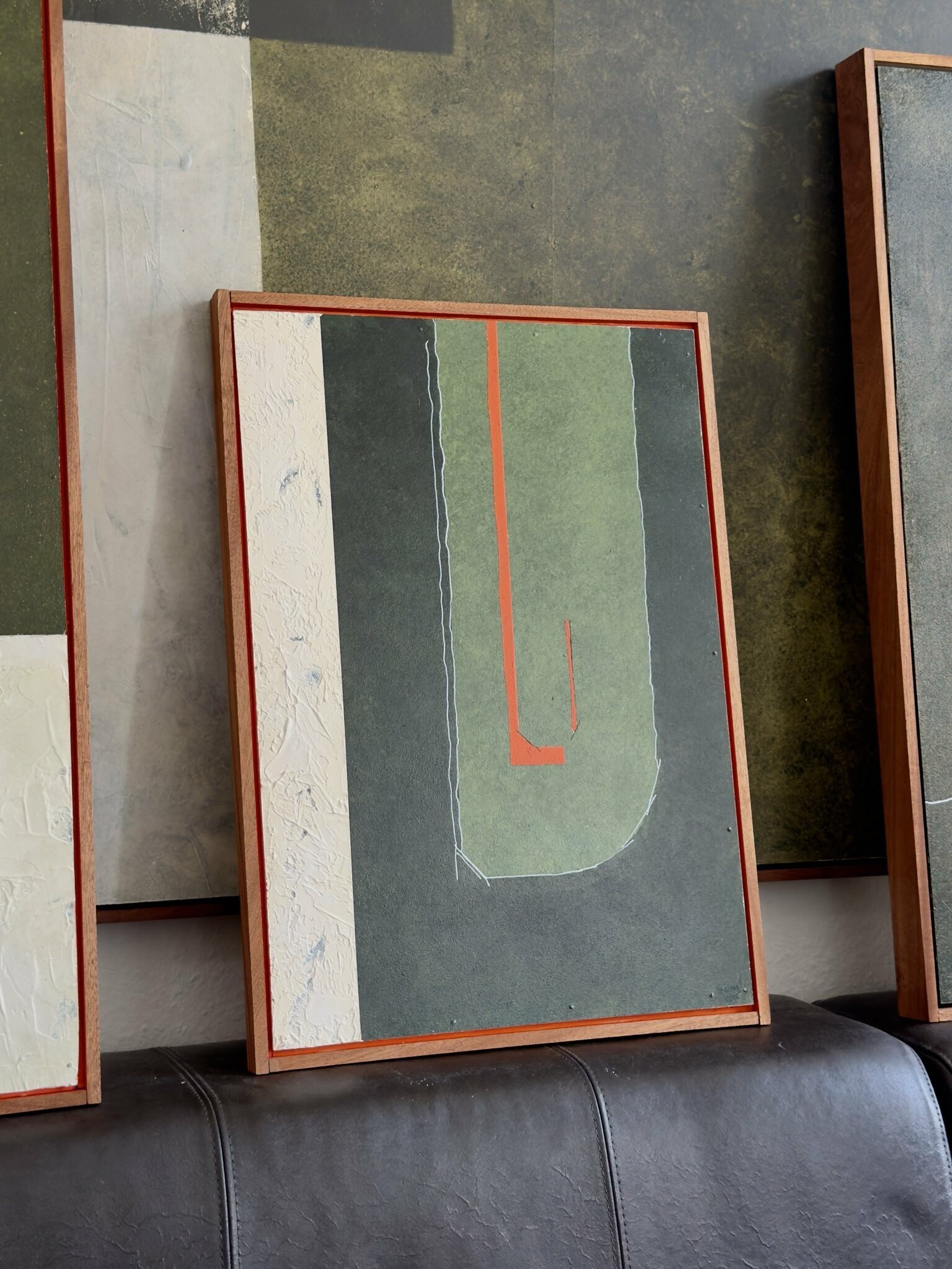 Strukturiertes, abstraktes Acrylgemälde mit einem großflächigen grünen Farbfeld. Ein hervorstechendes orangenes Element setzt einen starken farblichen Akzent. Ergänzt wird das Werk durch weiße Strichlinien und Gipsformen, die zusätzliche Tiefe und Ma