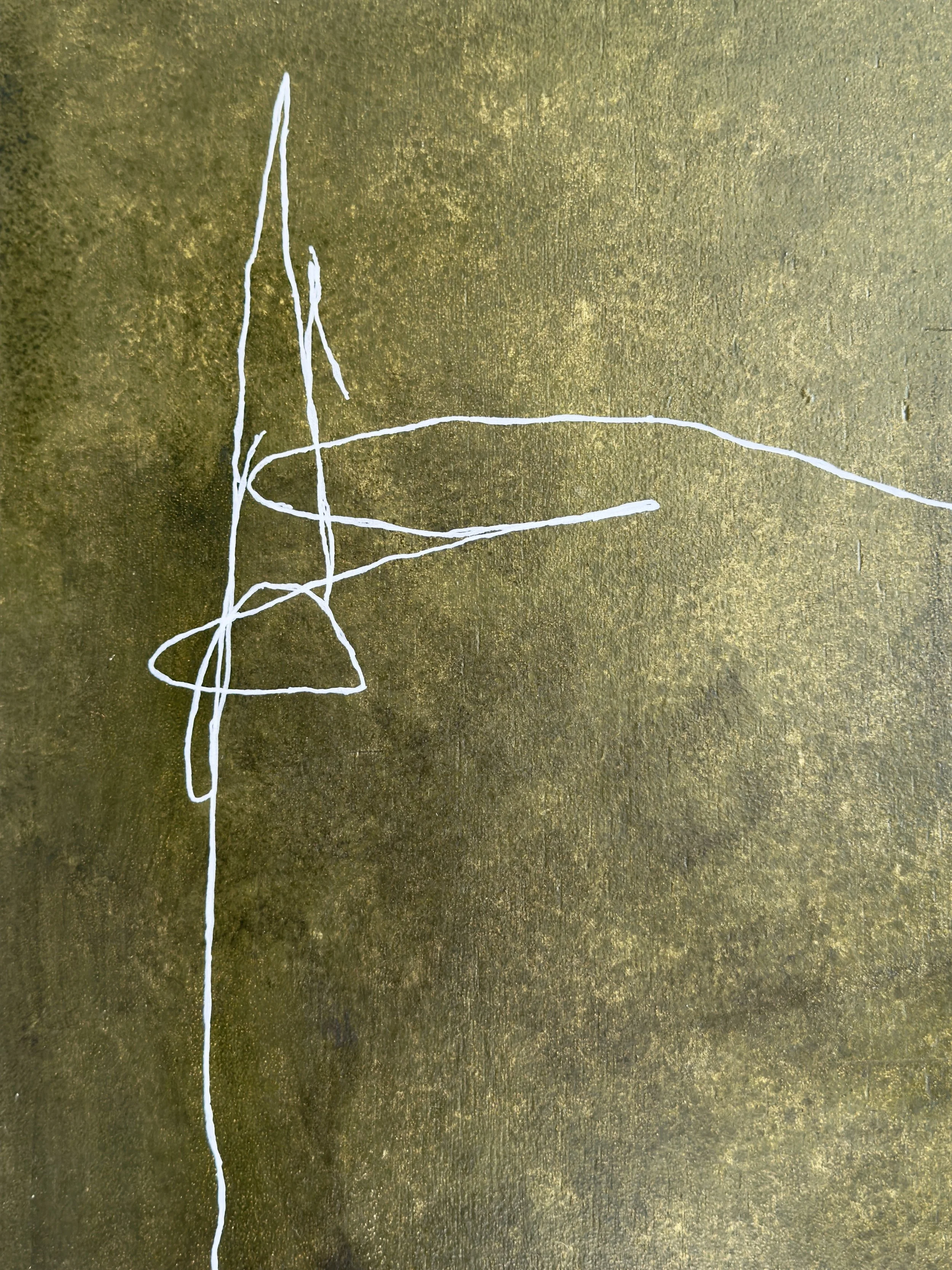 Graffiti auf einer goldfarbenen Wand, bestehend aus weißen Linien, die keine klare Form oder Bedeutung erkennen lassen.