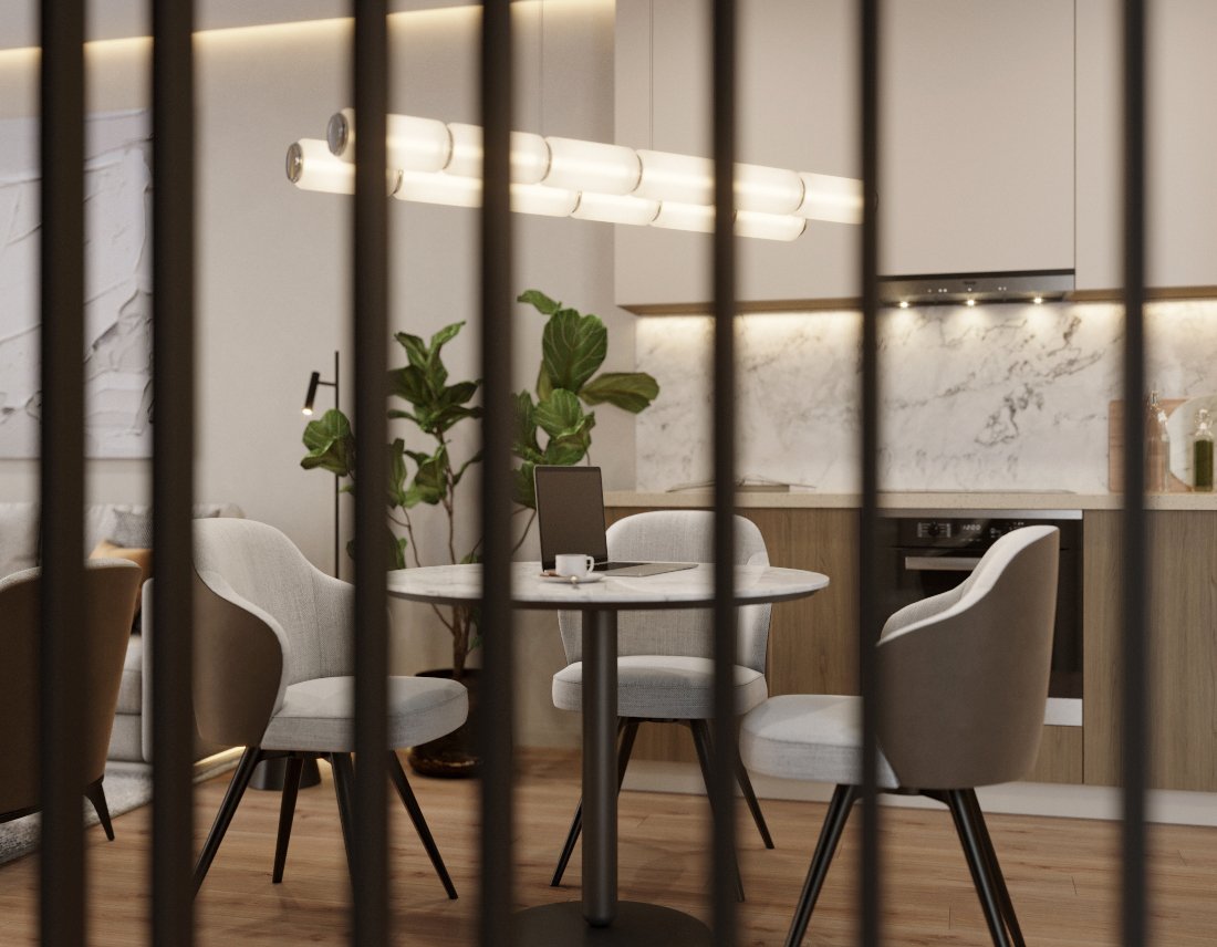 Modern dining area seen through black vertical bars, with a round table, four white upholstered chairs, a laptop, a coffee cup, large indoor plant, and a kitchen with marble backsplash in the background.