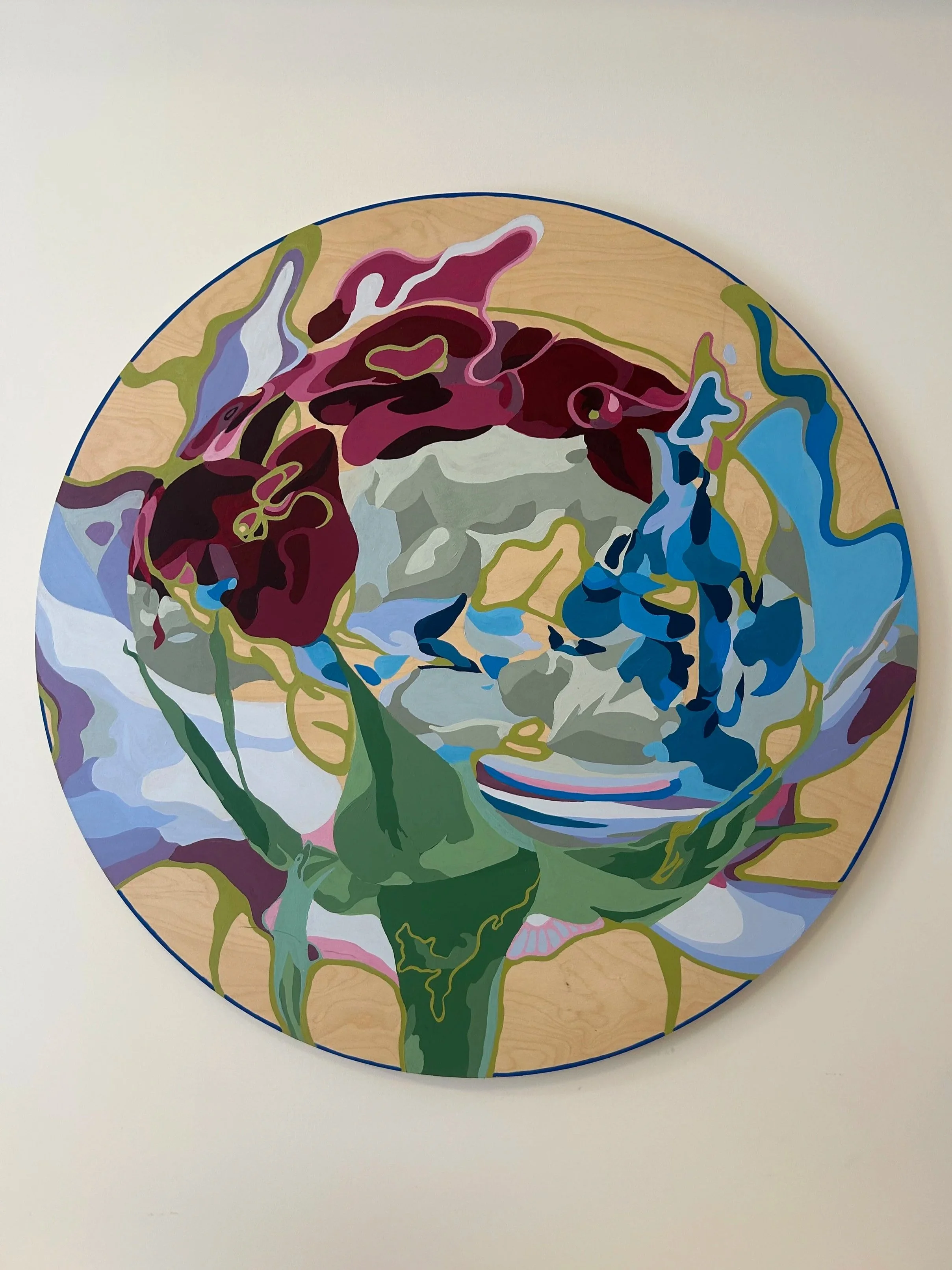 Colorful abstract painting of a flower on a round wooden surface.