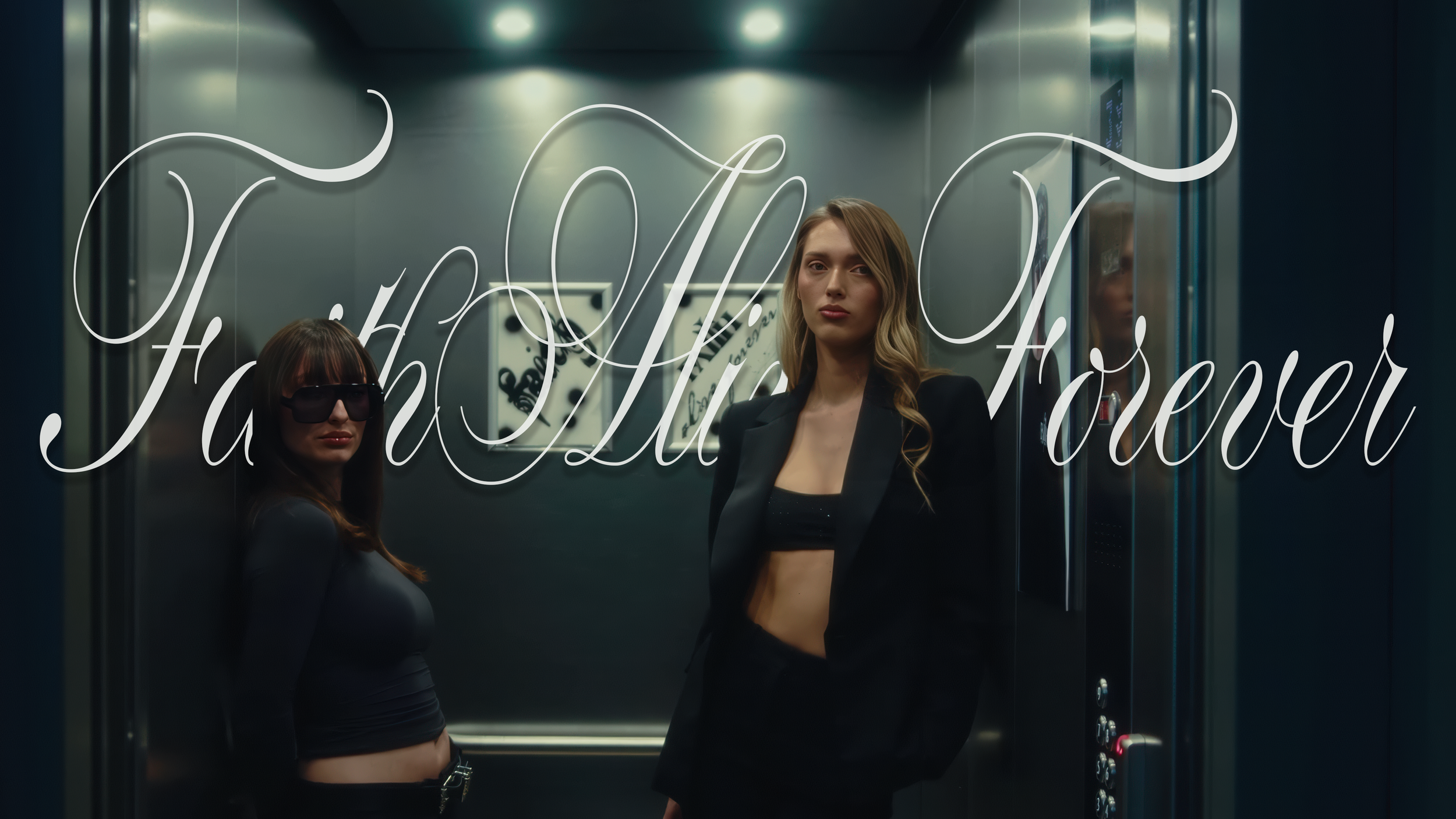 Two women standing inside an elevator, one with dark sunglasses and the other without, both dressed in black. The elevator door has "FaithAliveForever" written in cursive script.