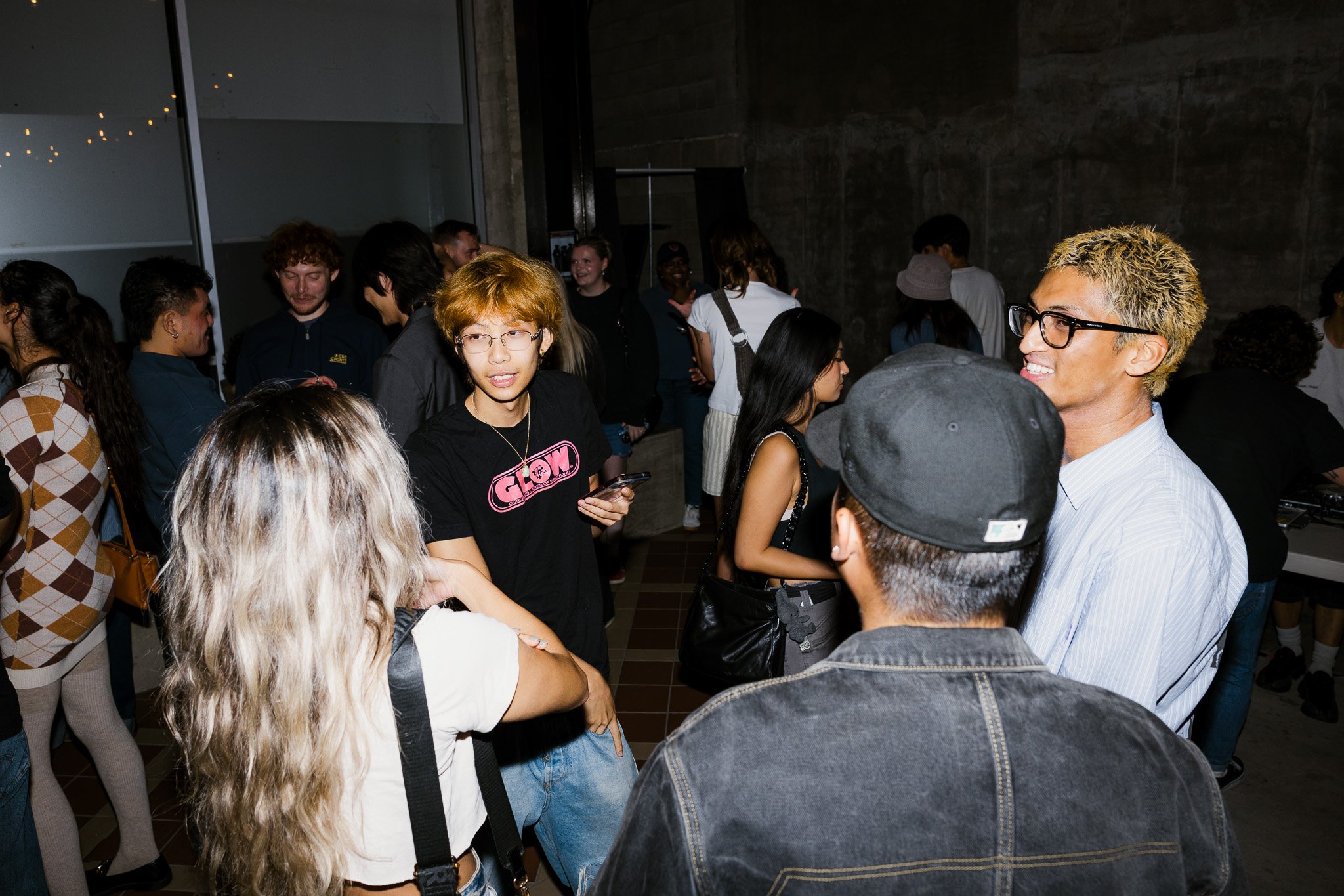 Group of young people socializing at a party or gathering indoors.