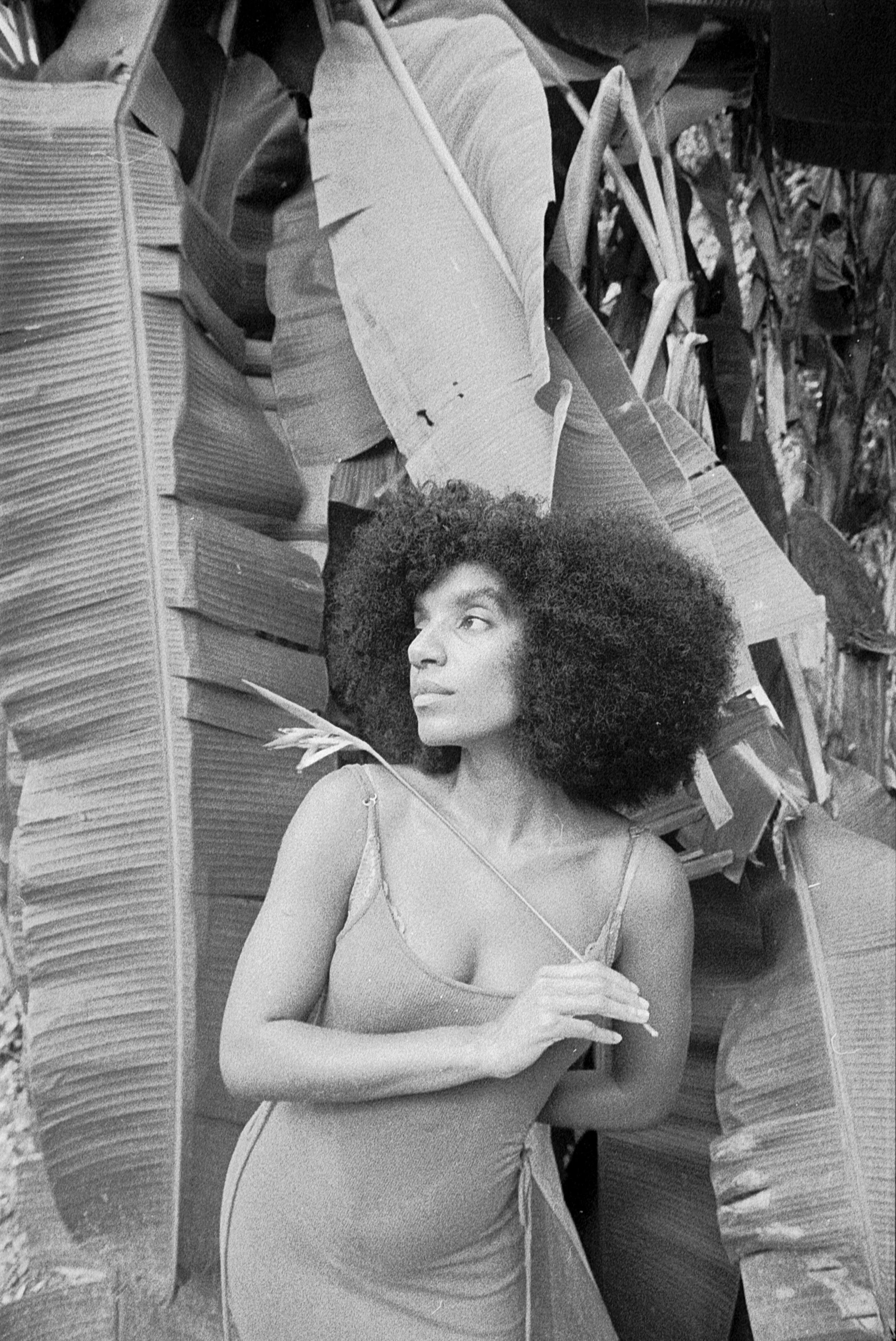 Woman in Brasil standing in front of a banana tree holding a flower