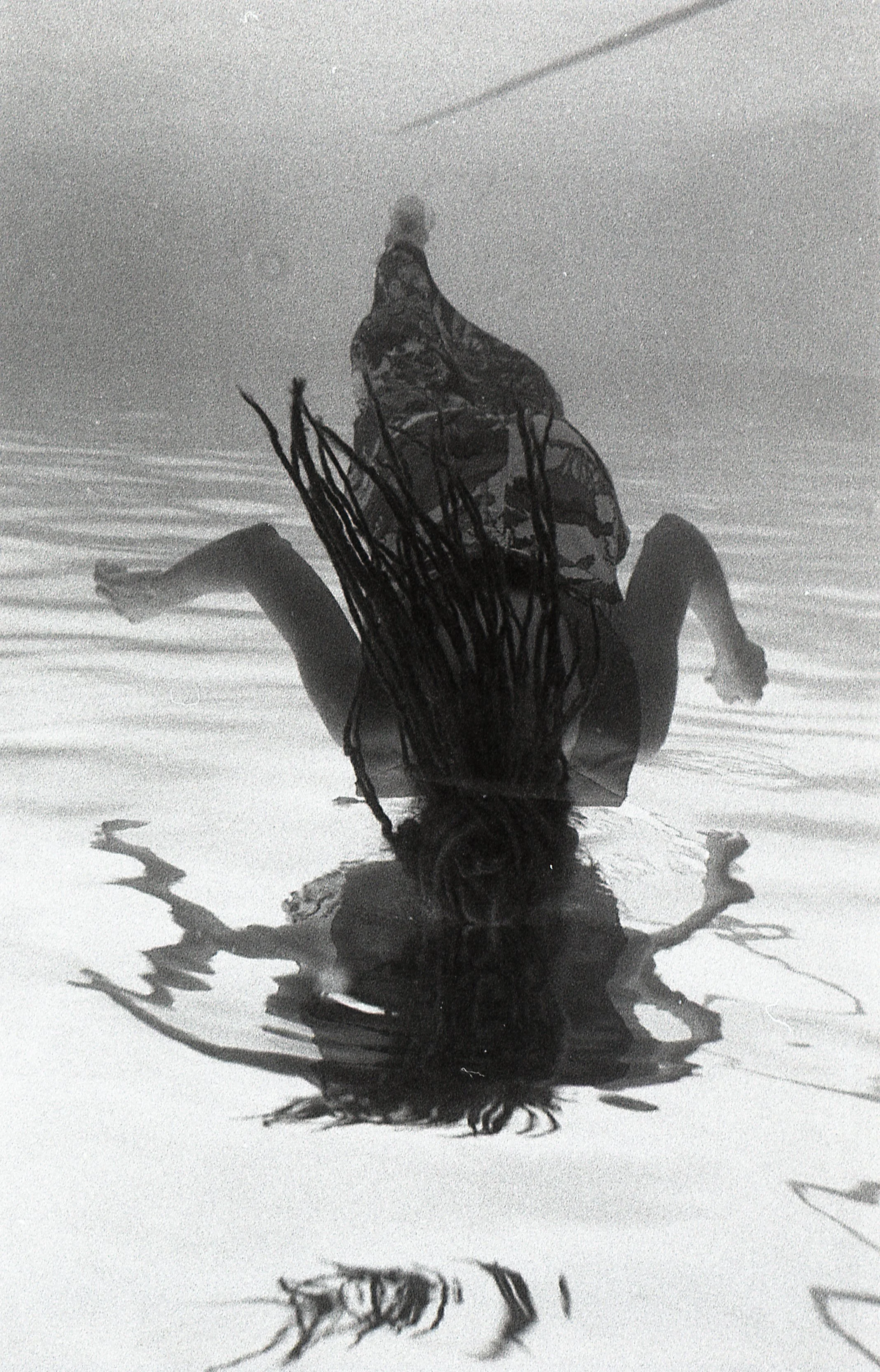 An vantage point underneath a woman that is floating in a pool.