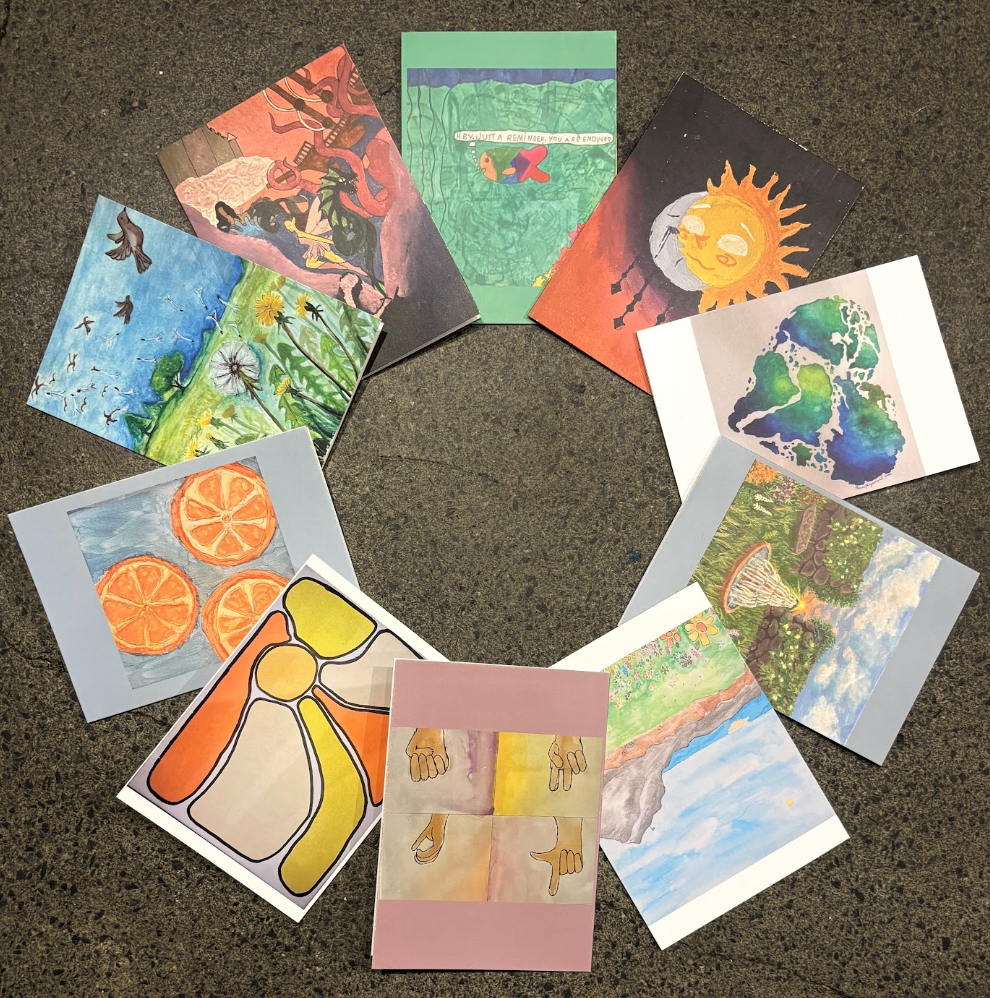 A collection of colorful handmade cards arranged in a circle on a dark surface.