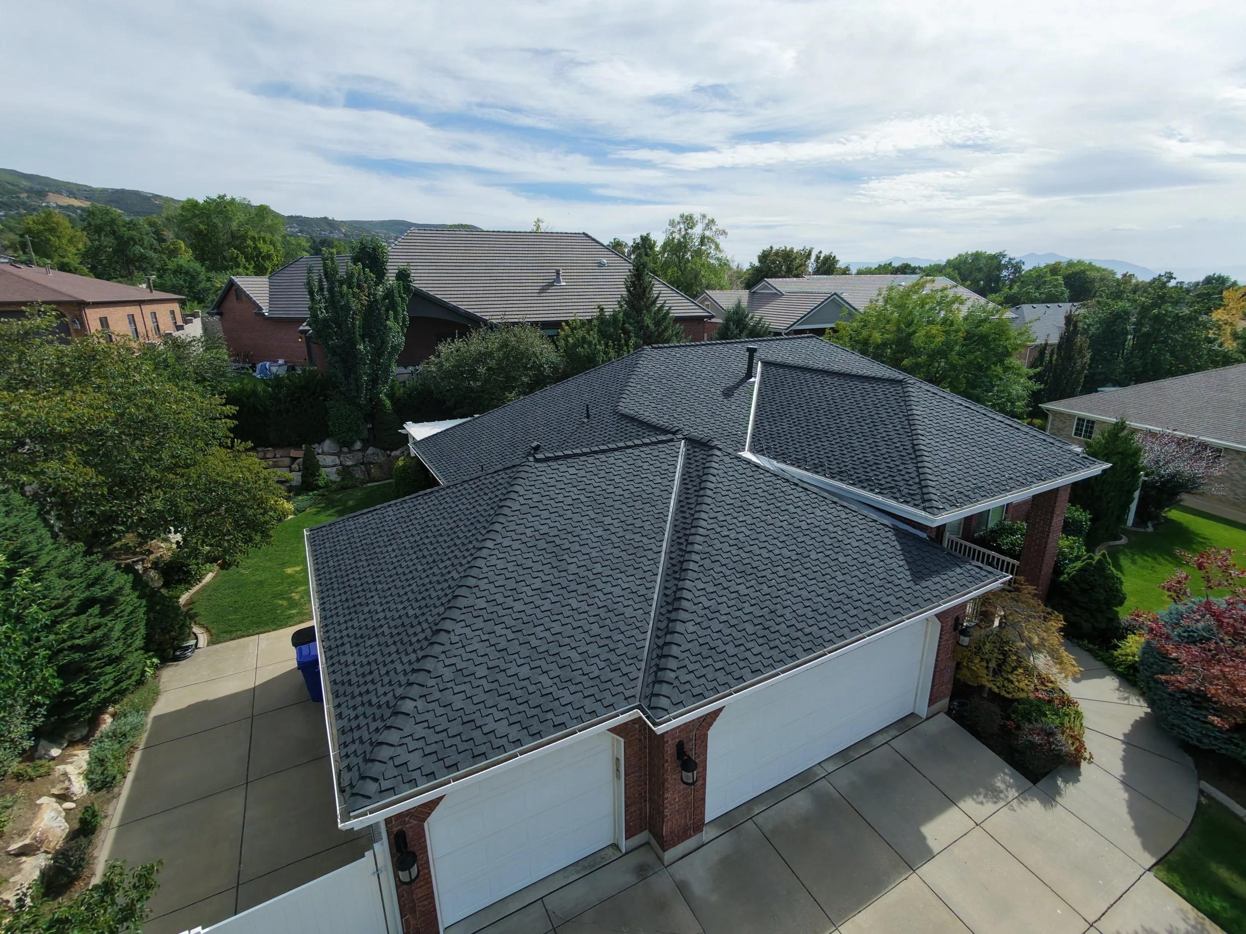Birds Eye view of a beautiful red brick house with a new black roof in Bountiful Utah