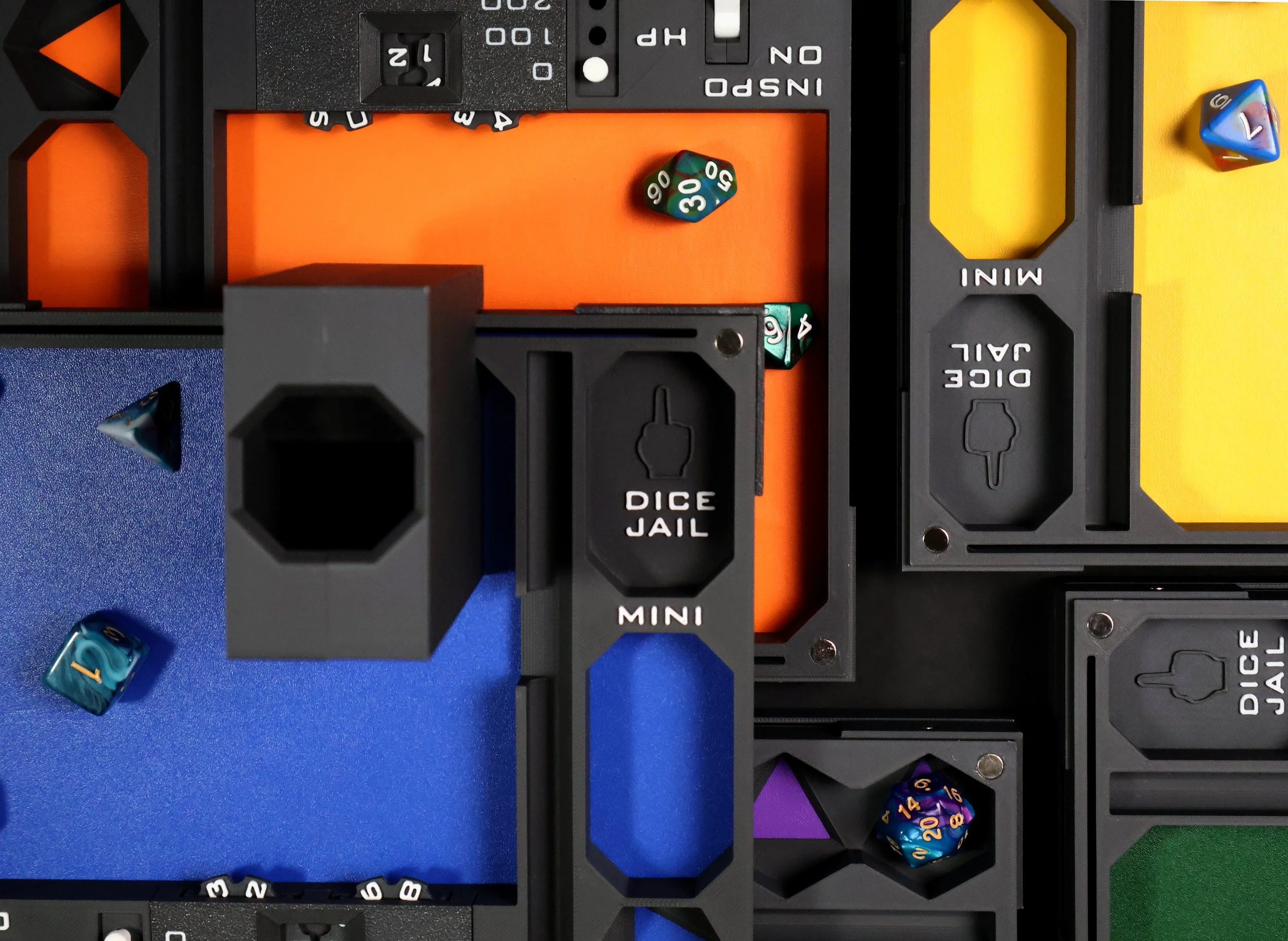 Close-up of a colorful tabletop board game setup featuring various sections labeled 'Dice Jail,' 'Mini,' and 'Idle Jail,' with multicolored dice inside and around the sections.