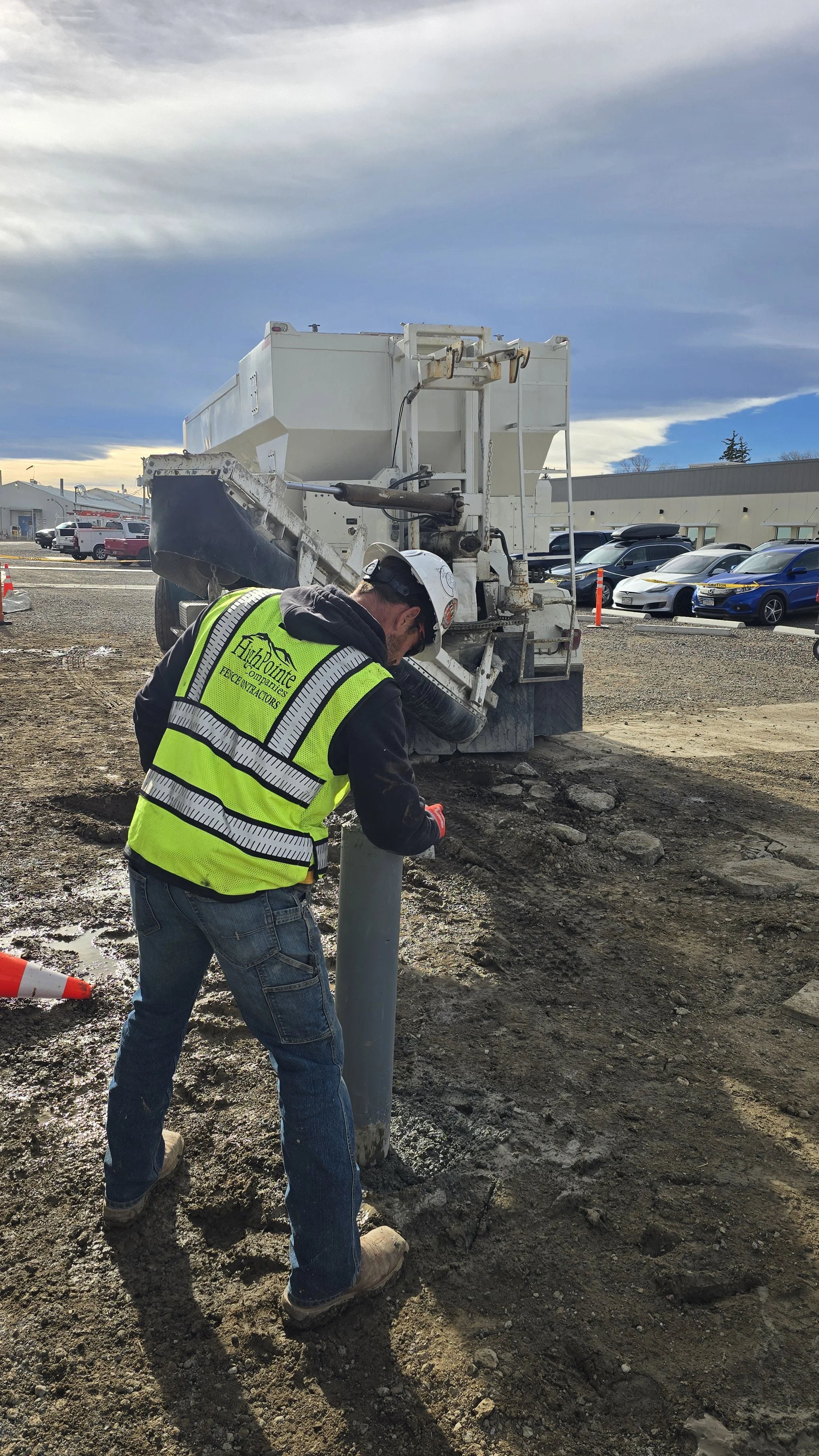 Construction guy putting in concrete bollard.
