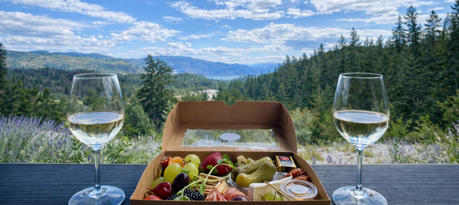 Charcuterie box and wine glasses at winery overlooking the Okanagan Valley