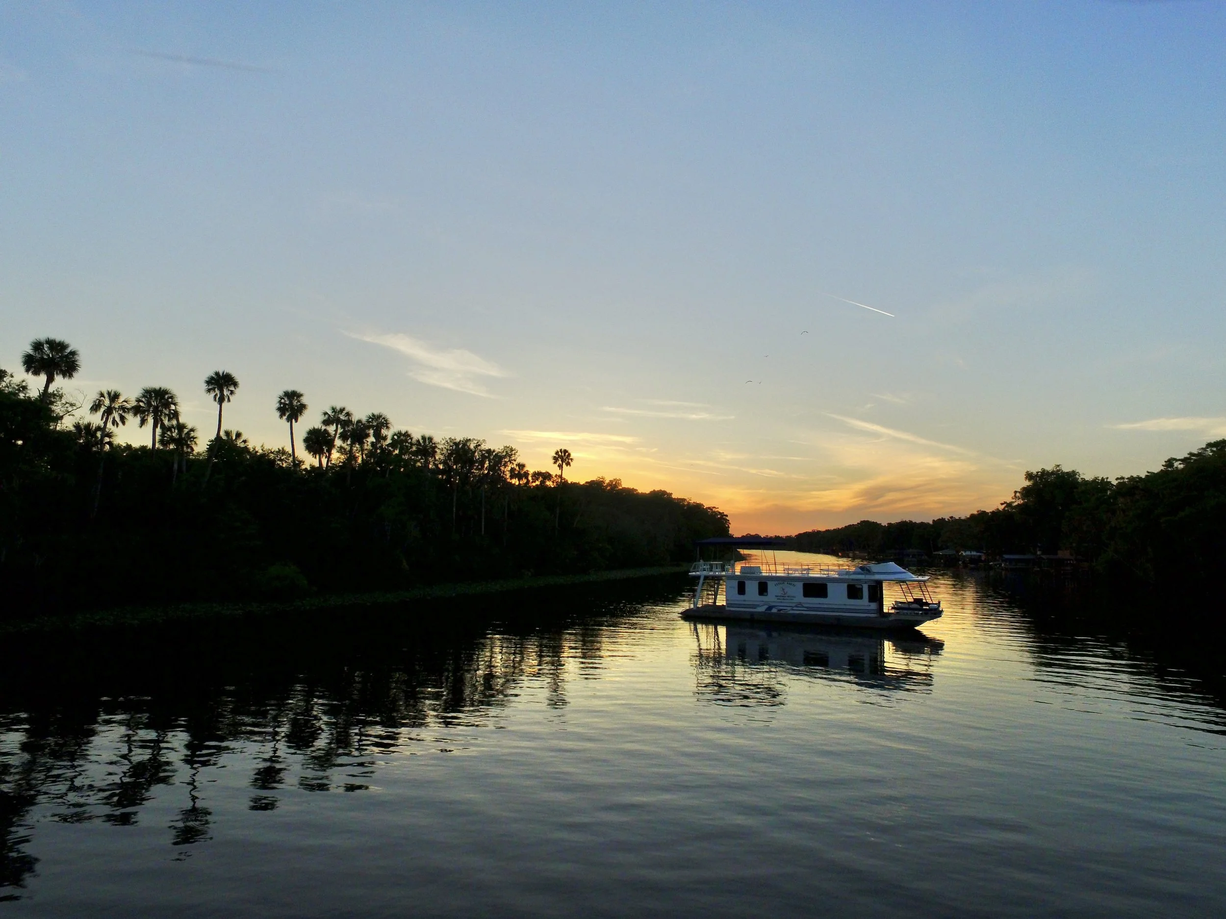 Houseboat sitting on the St. Johns River at sunset.