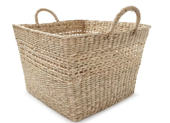 A woven wicker basket with two handles on a white background.