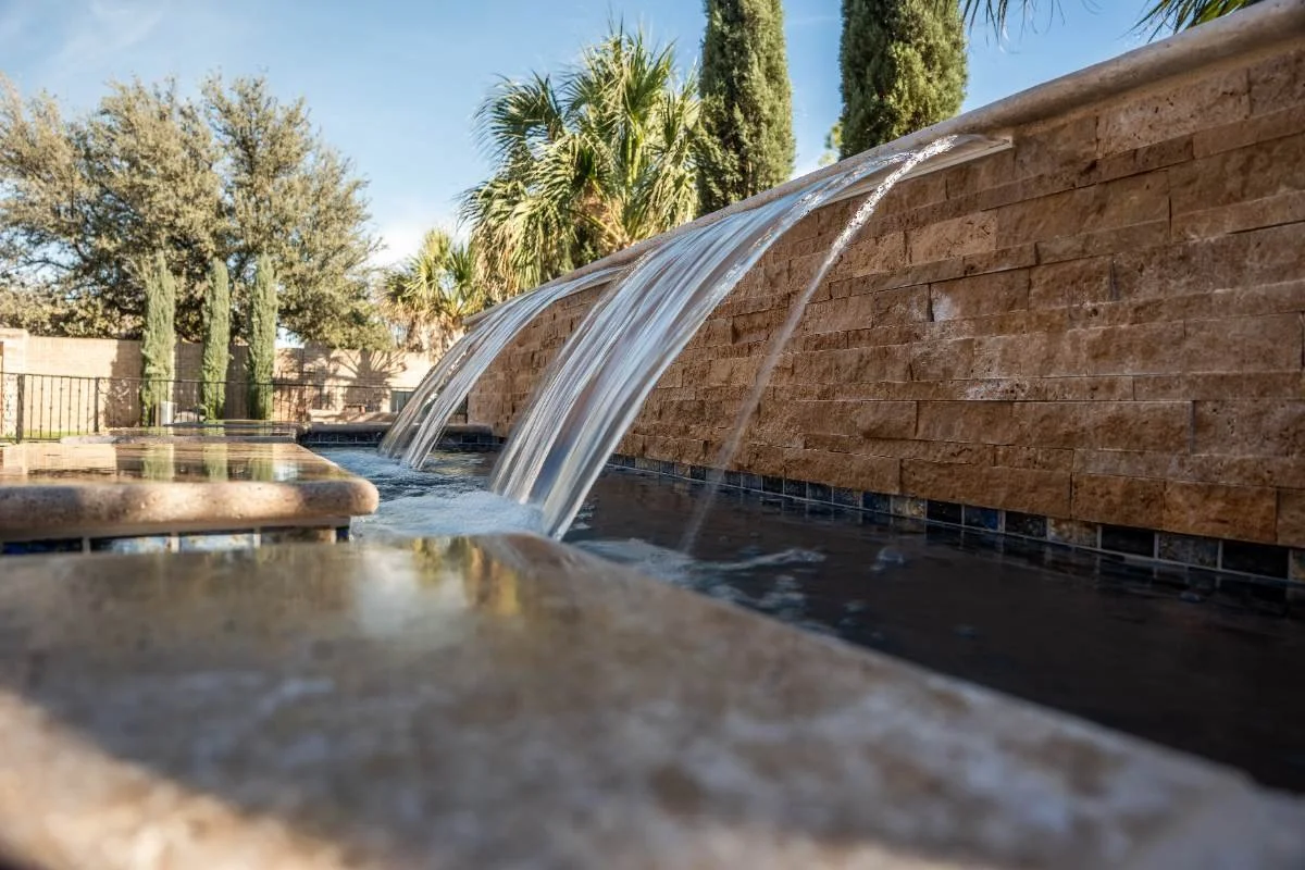 Modern pools & spas water feature rebuild with cascading scuppers and artificial turf integration in Fort Stockton, TX