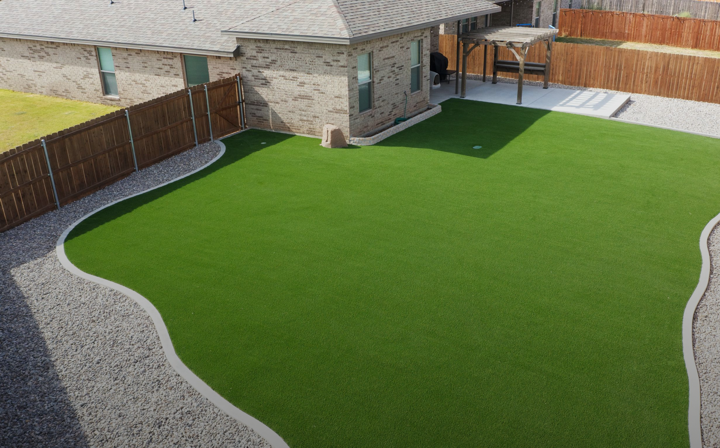 Artificial turf installation creating a seamless backyard lawn in Odessa, TX