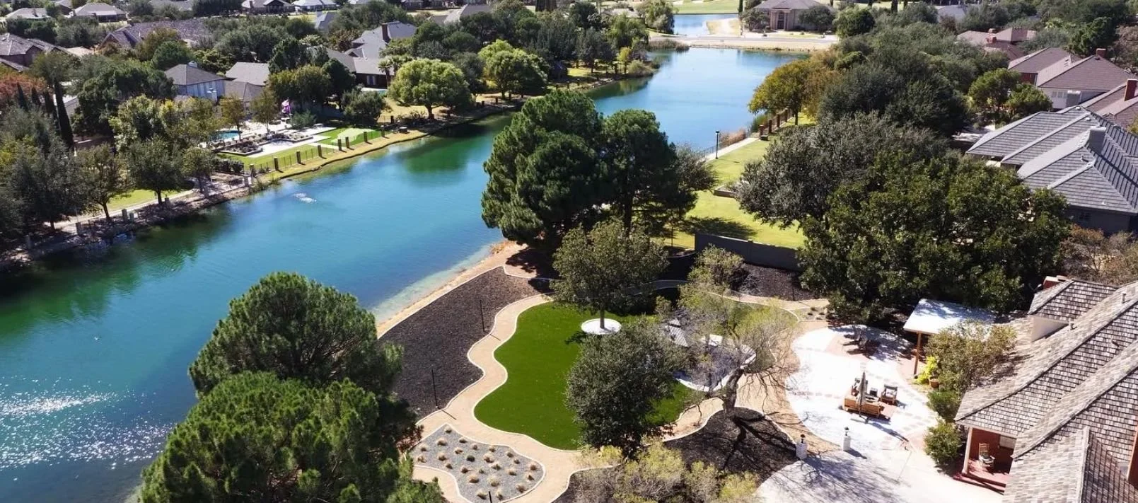 Expansive lakeside property enhanced with synthetic turf, gazebo structure, and cohesive landscape design in Midland, TX