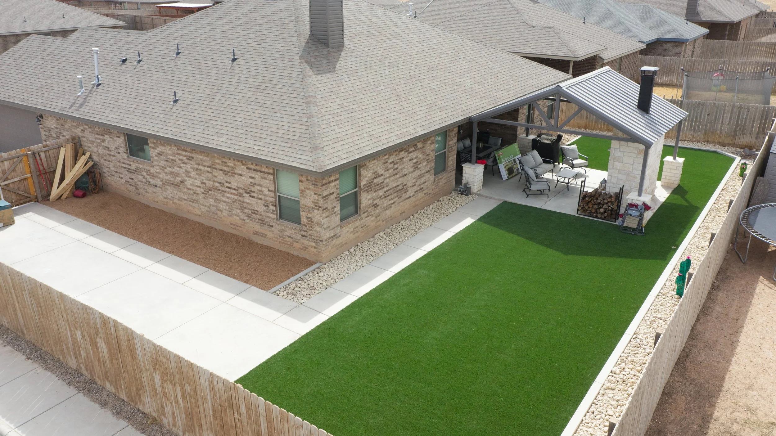 Completed outdoor living space with artificial turf and custom patio builder near me project in Odessa, TX