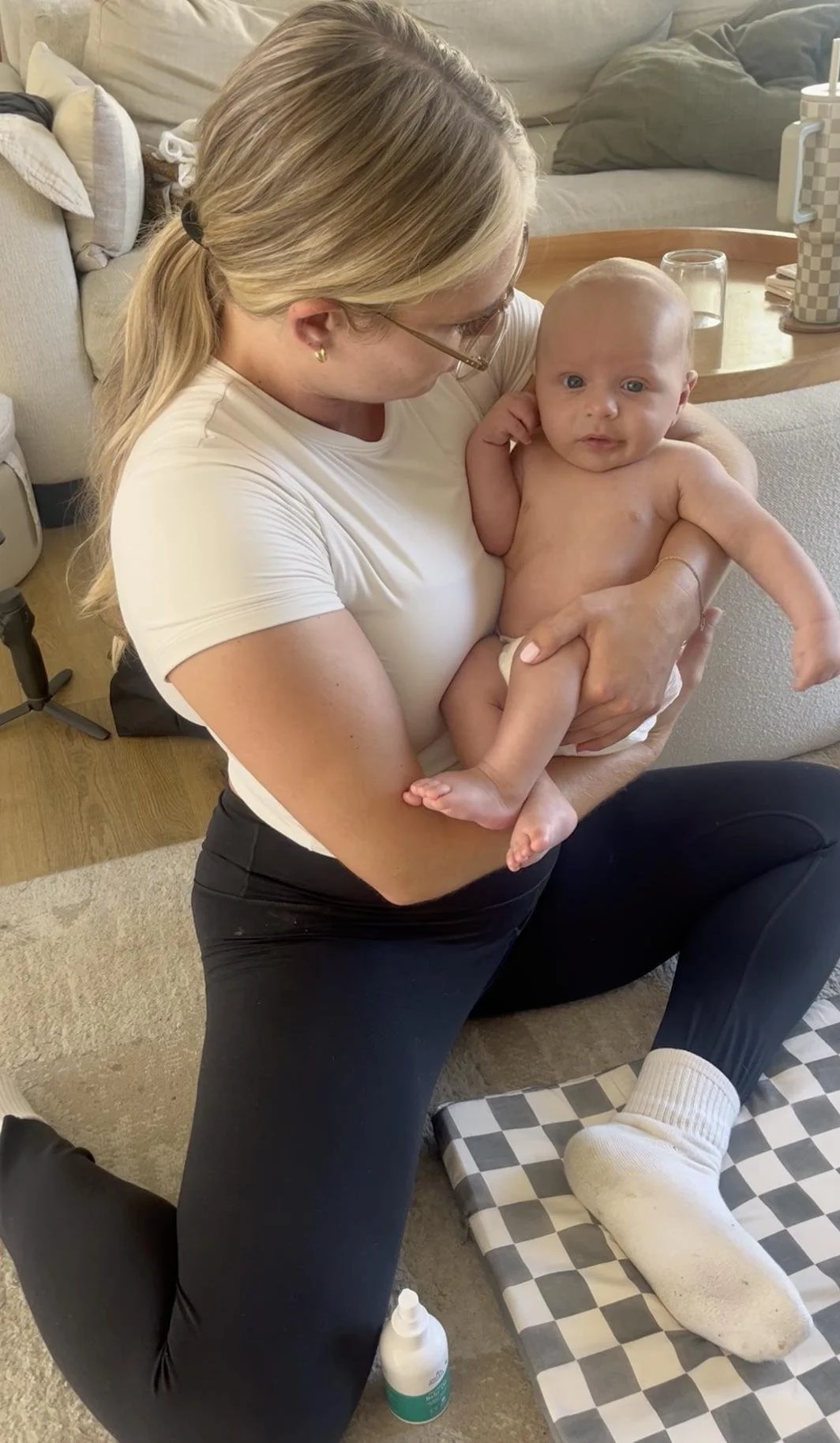 Pediatric physical therapist supporting a baby in an upright position during an in-home torticollis session in Costa Mesa, CA.