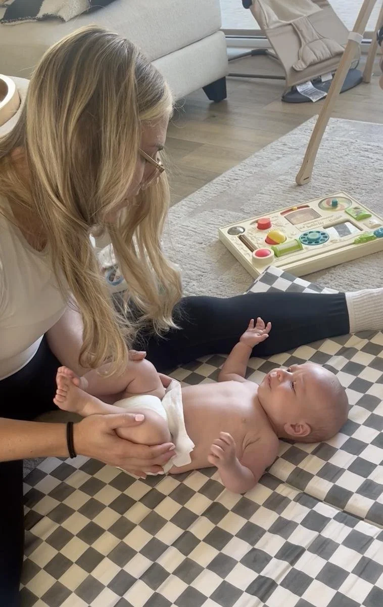 Pediatric physical therapist working on a baby's hips and legs during an in-home visit serving Newport Beach, CA.