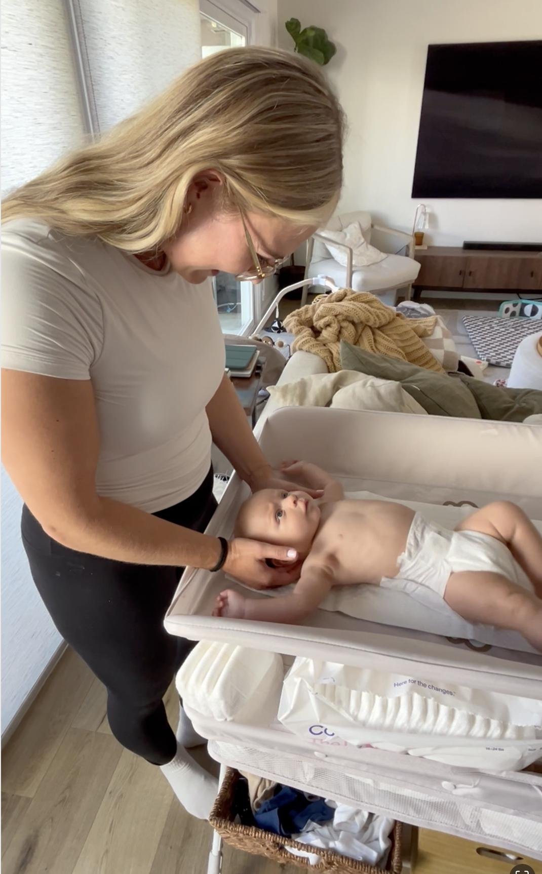 Dr. Avonlea Brown working with an infant on a changing table during an in-home pediatric visit — Avonlea Brown Physical Therapy, Costa Mesa, CA.