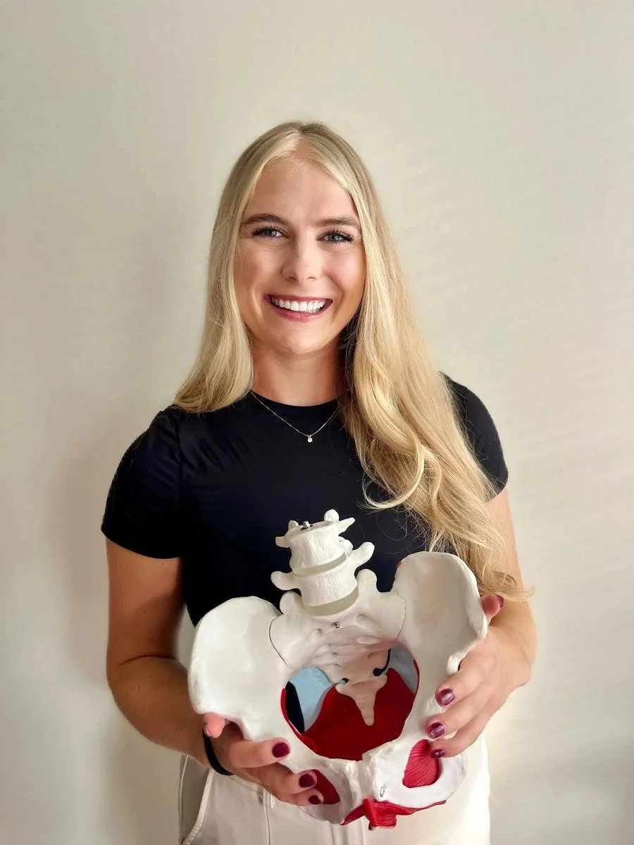 Dr. Avonlea Brown, PT, DPT smiling and holding a pelvic anatomy model in Costa Mesa, CA — Avonlea Brown Physical Therapy, Costa Mesa, CA.