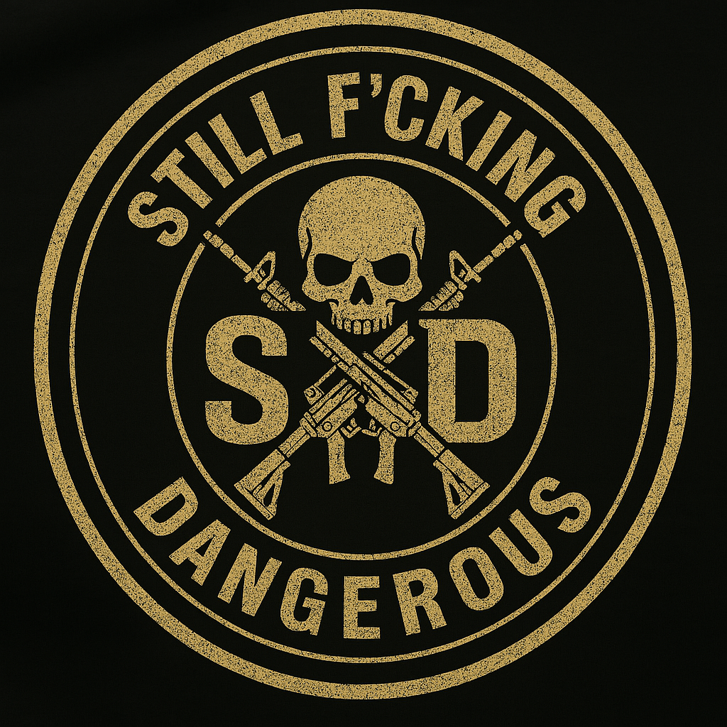 A circular emblem with a skull in the center, crossed by two rifles, and the text 'Still F*cking Dangerous' and 'SD' around the skull. The design is in gold on a black background.