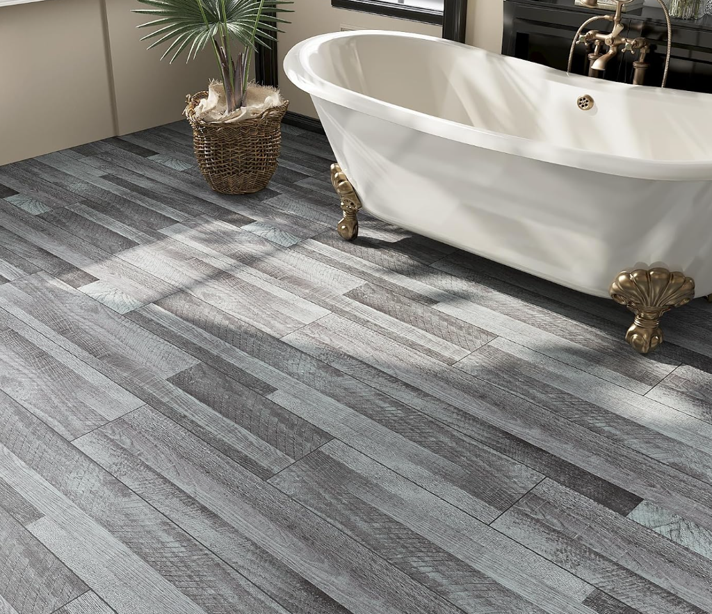 A bathroom with a vintage-style white clawfoot bathtub, a potted plant in a woven basket, and wood-look tile flooring.