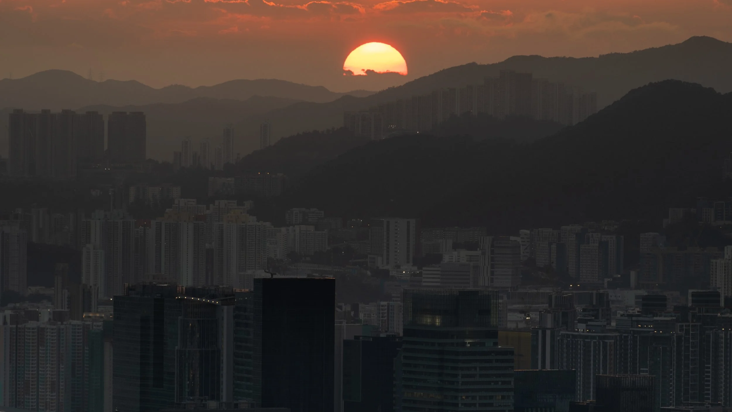 The Orange Sunset: Sun is setting over Kowloon while the city is about to fall into darkness (Kowloon, Hong Kong)