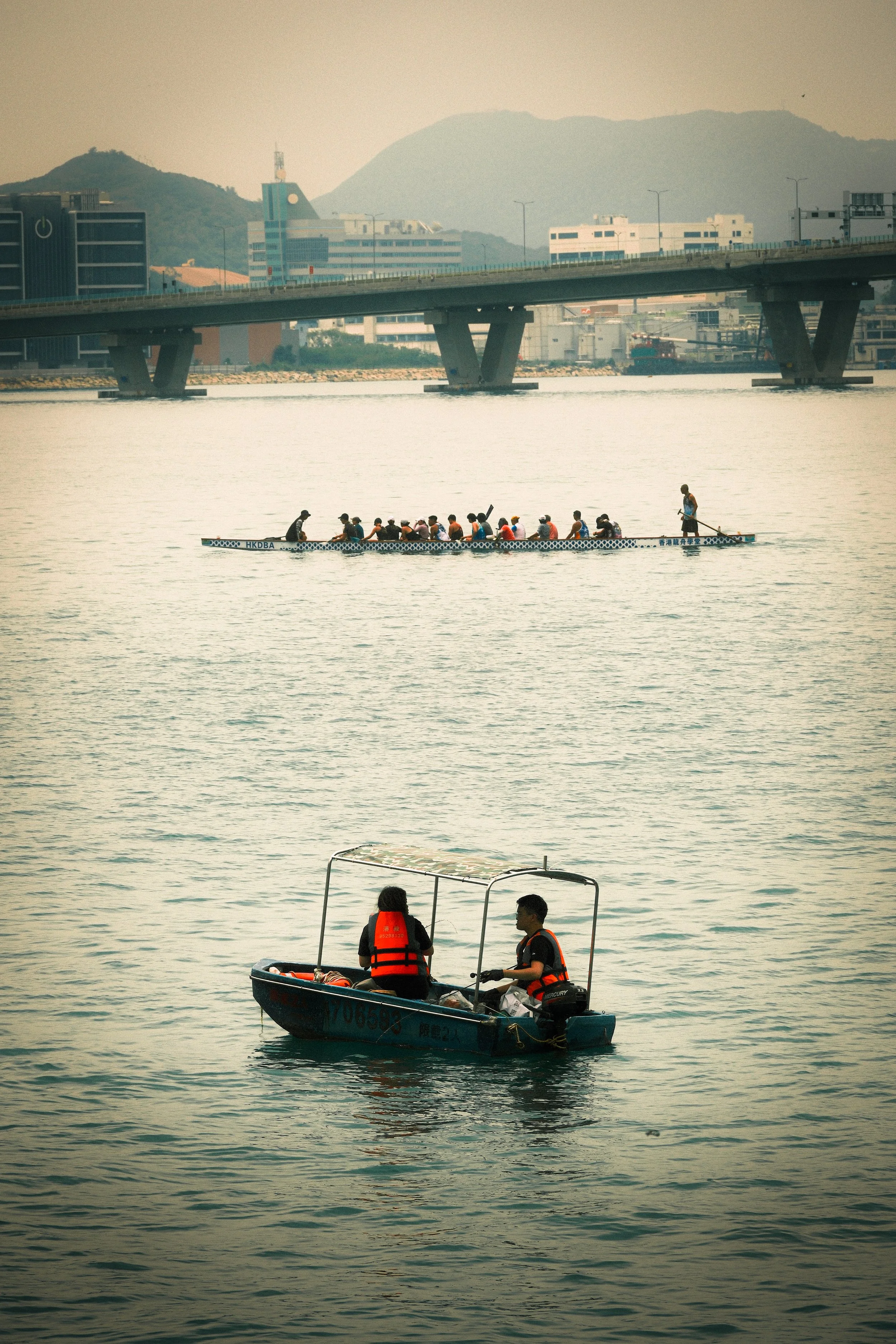 For Leisure or Sport: Hong Kong's waters host leisure sailors in the foreground, while dragon boat racers train in the distance.
