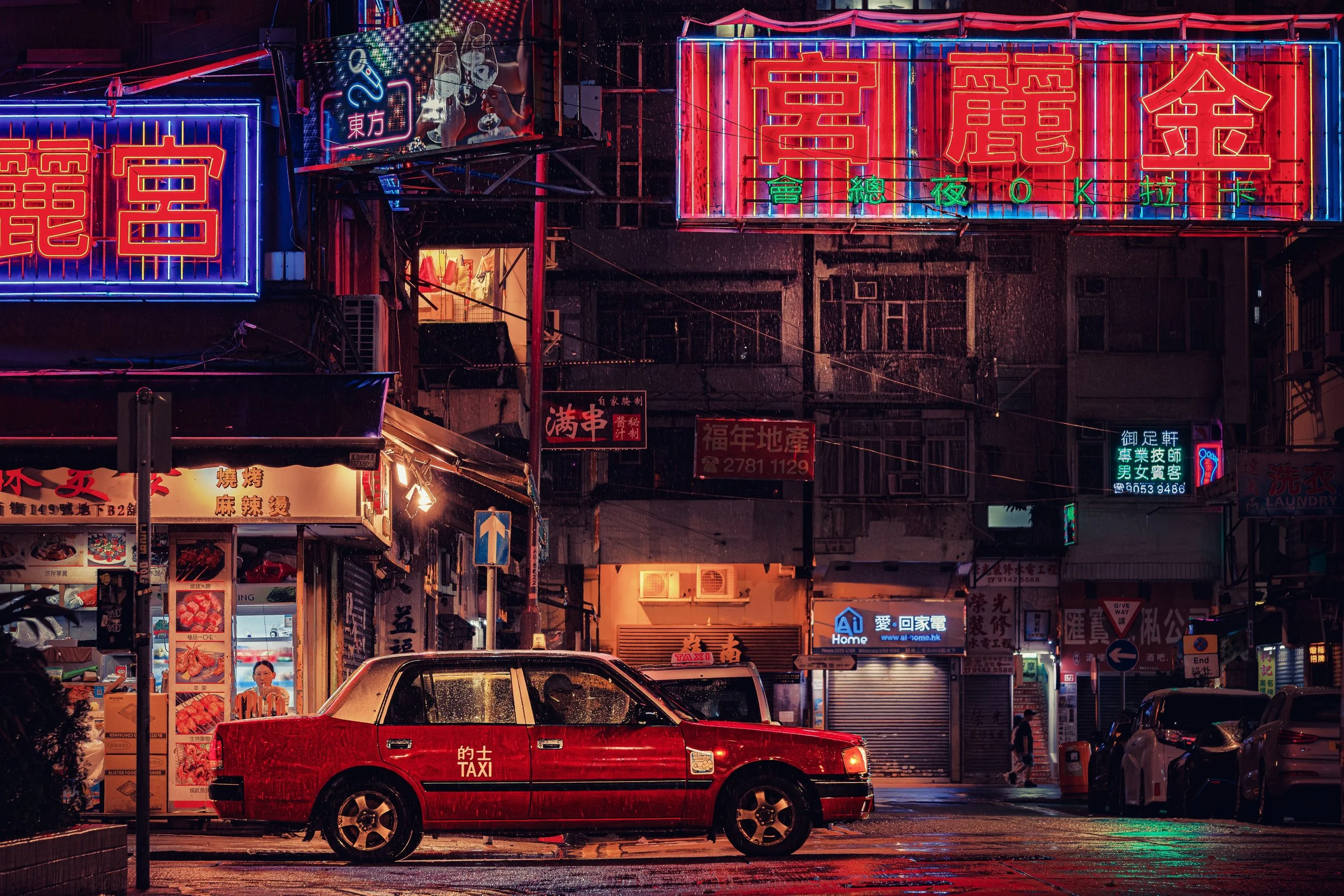 Rainy Neon Night: An iconic red Hong Kong taxi standing below one of the remaining Mongkok neons.