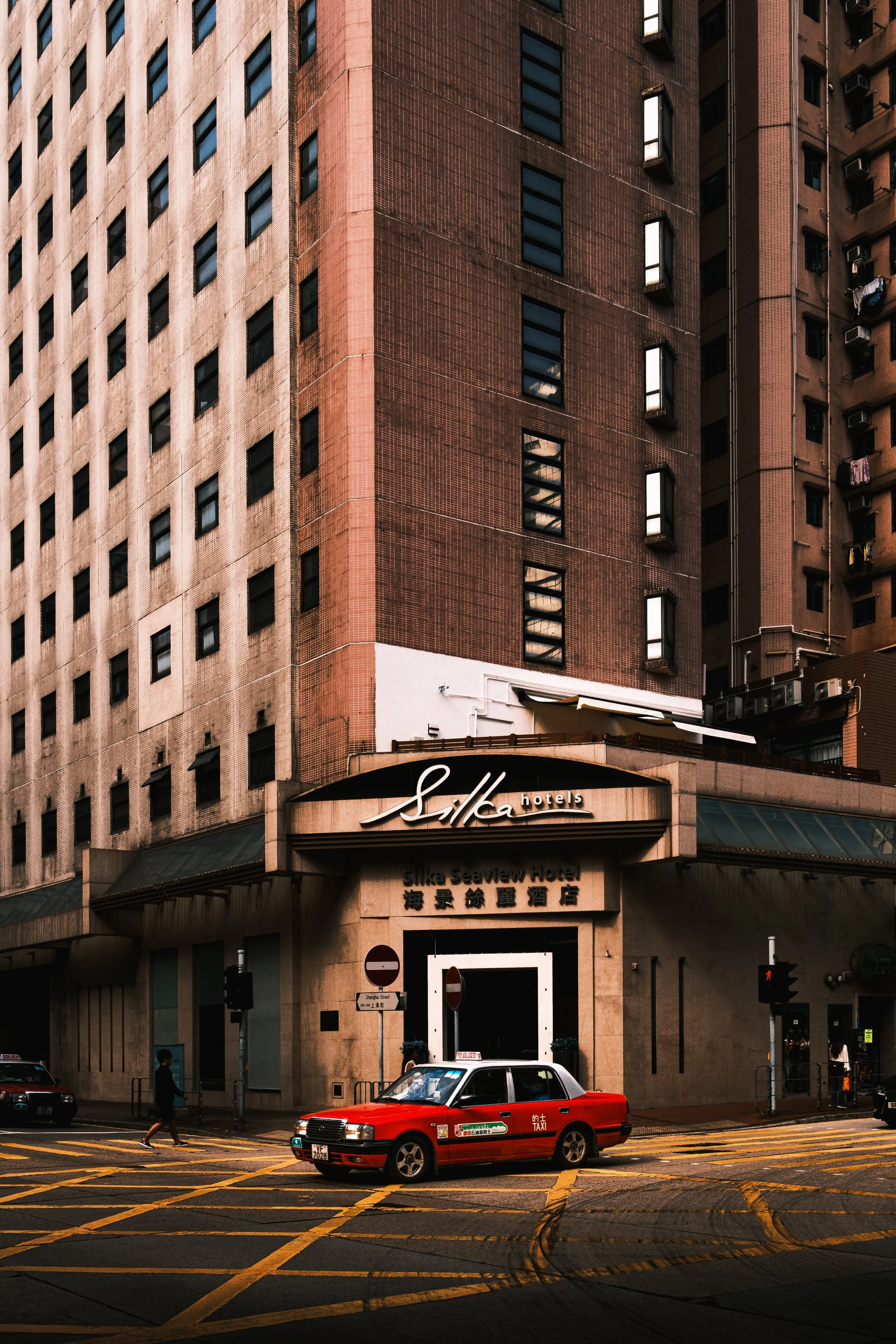Silka Hotels: An iconic Hong Kong red taxi in front of the Kowloon Silka Hotels building.