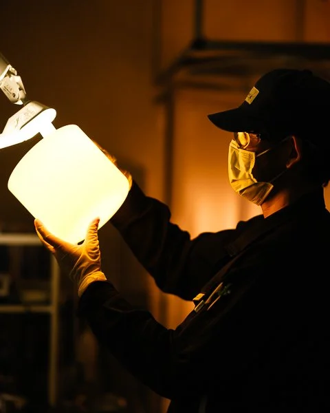 worker-checks-crucible-under-lamp.jpg
