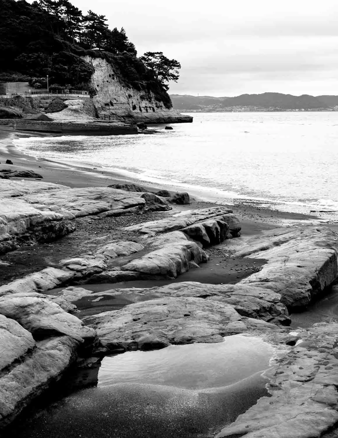  Rocky shoreline with tidal pools near Kamakura, photographed in black and white by Japan photographer Ben Weller as part of “The Shore. 