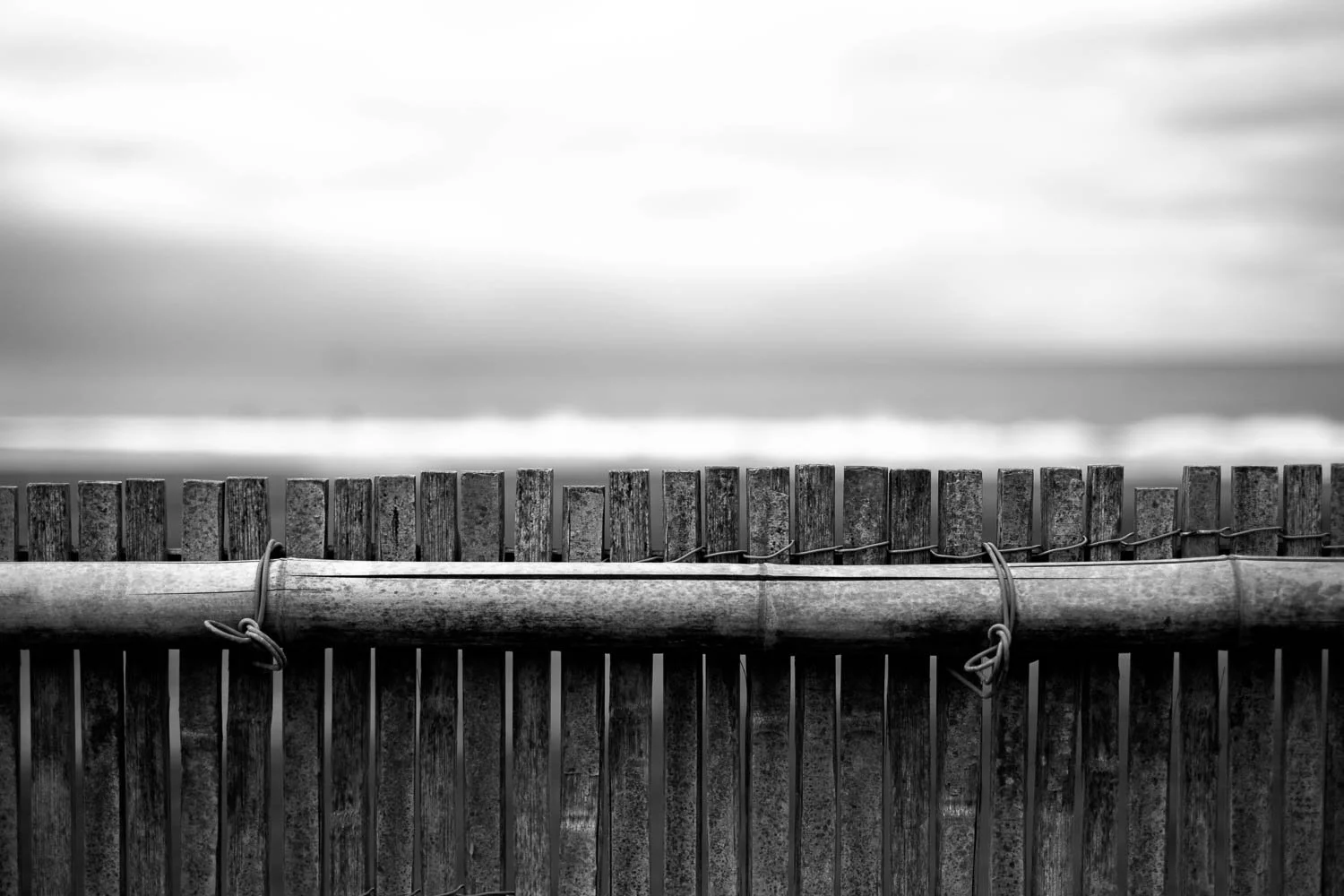  Weathered bamboo fence standing against the sea, a quiet coastal detail from “The Shore,” photographed in Kanagawa Prefecture. 