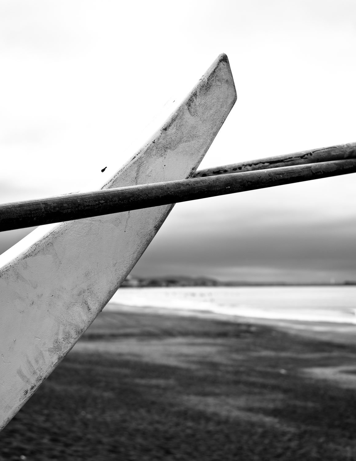 Minimalist black and white study of a boat rudder against the sea horizon, photographed on a beach in Fujisawa, Japan. 