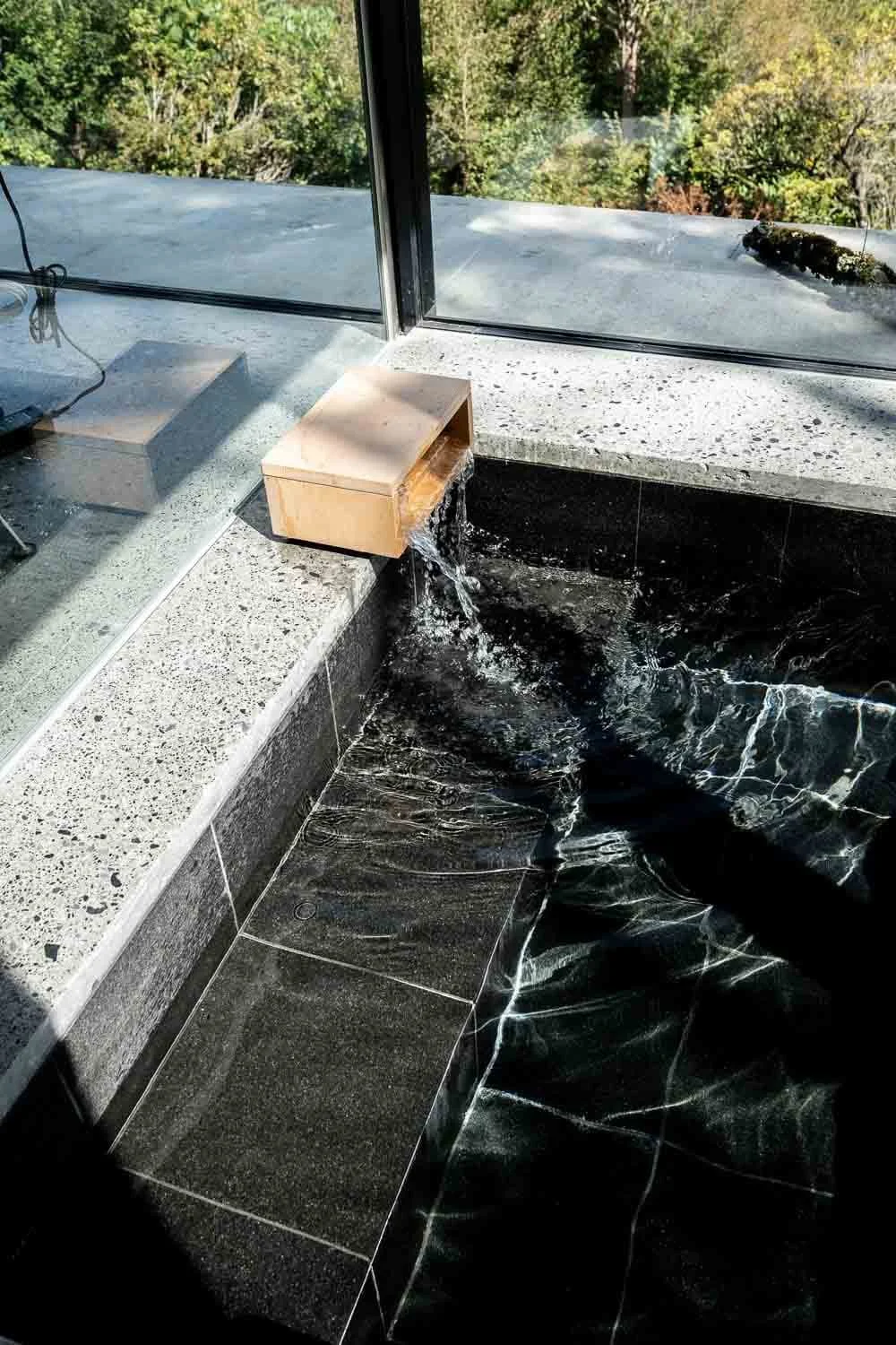 The home’s hinoki-wood, spring-fed tub draws water directly from the mountain and opens to views of the forest below. 