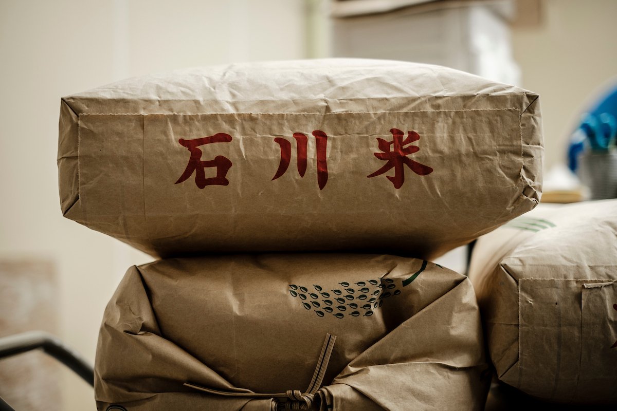  Bags of white rice, stamped with Japanese characters reading "Ishikawa Rice", at the Takemoto rice farm in Nomi, Ishikawa, Japan. 