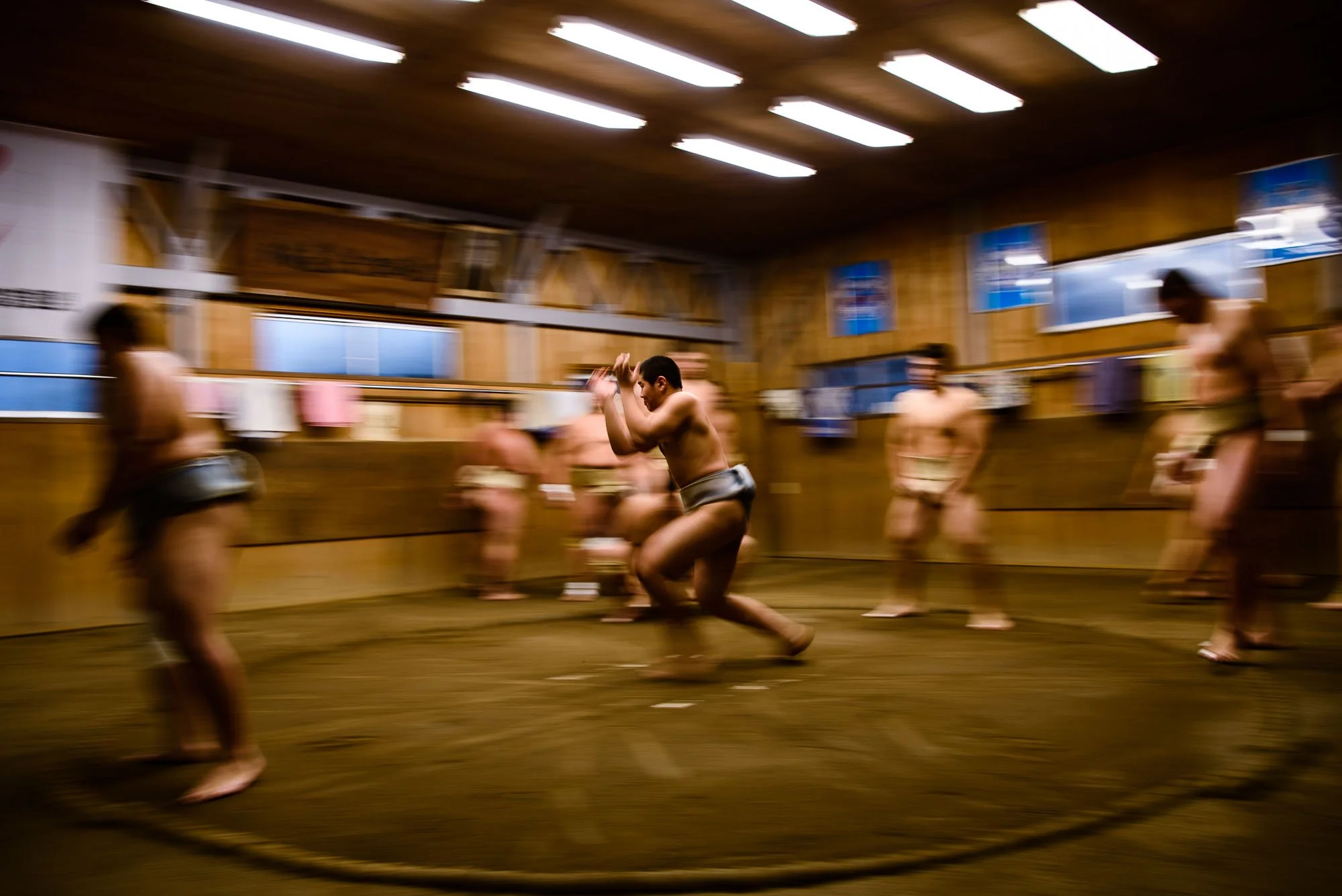 Action sports photography image of young sumo wrestlers training in a Japanese dojo.