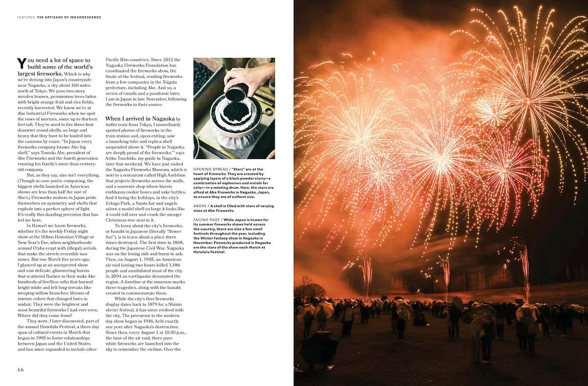 Large group of people watching fireworks lighting up the night sky over a beach in Nagaoka, Japan, with vibrant orange and red bursts.