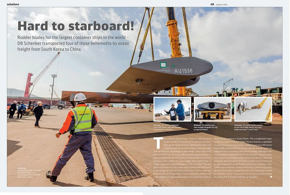Workers and engineers on a dockyard unloading large container ship component using a crane, with a bright cloudy sky in the background.