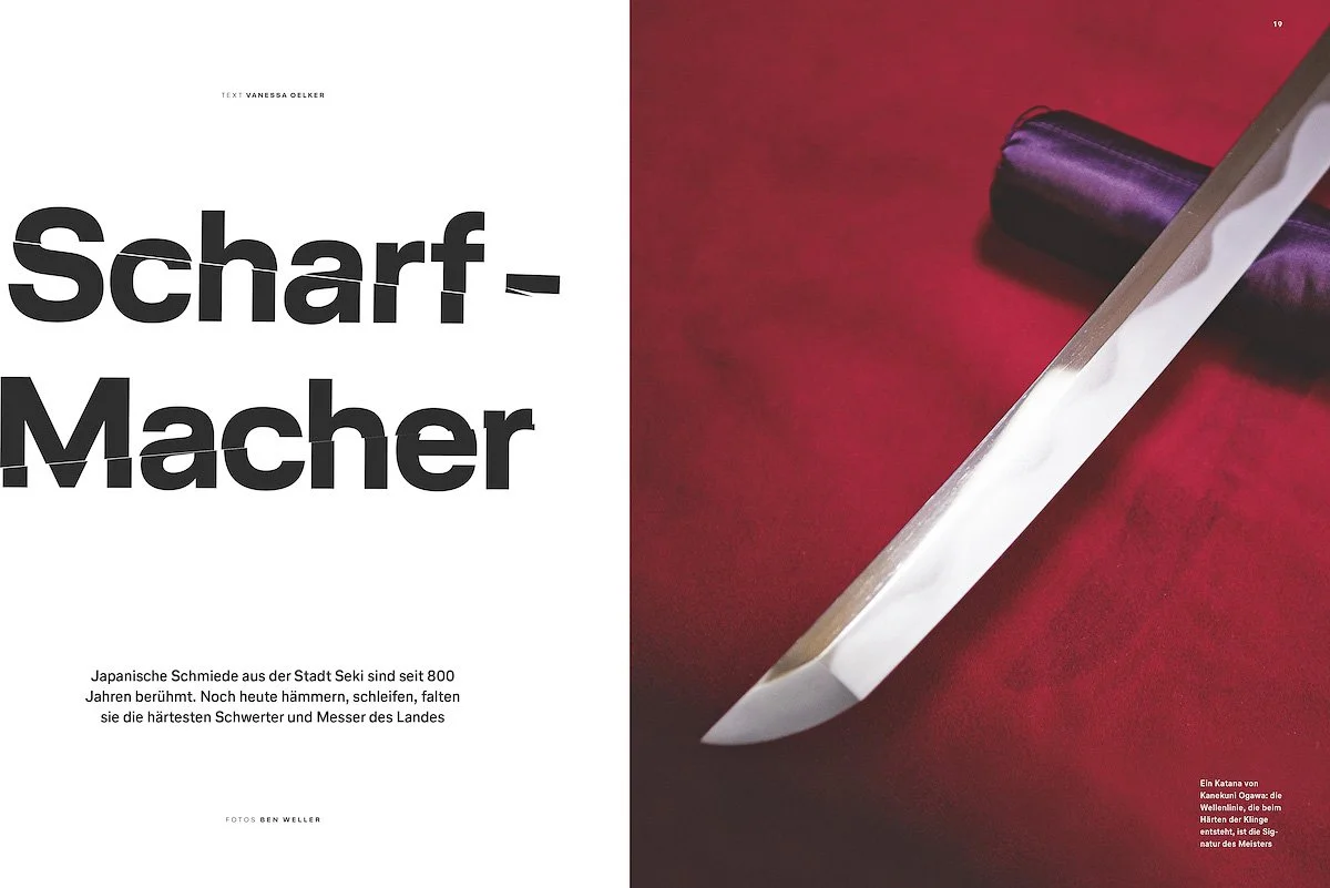 A Japanese knife with a shiny blade and a dark handle on a red surface.