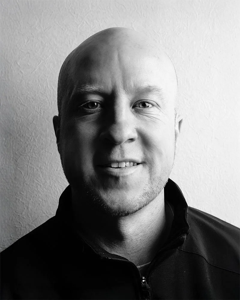 A black and white portrait of Japan-based photojournalist Ben Weller.